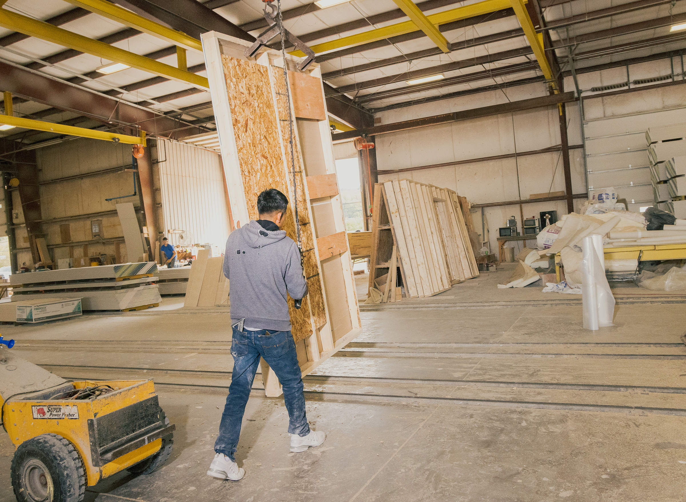 Moving a wall of the home from the production area to storage, to be used later on the rail system shown, in the factory of Apex Homes, in Middleburg, Pa. on Oct. 12.