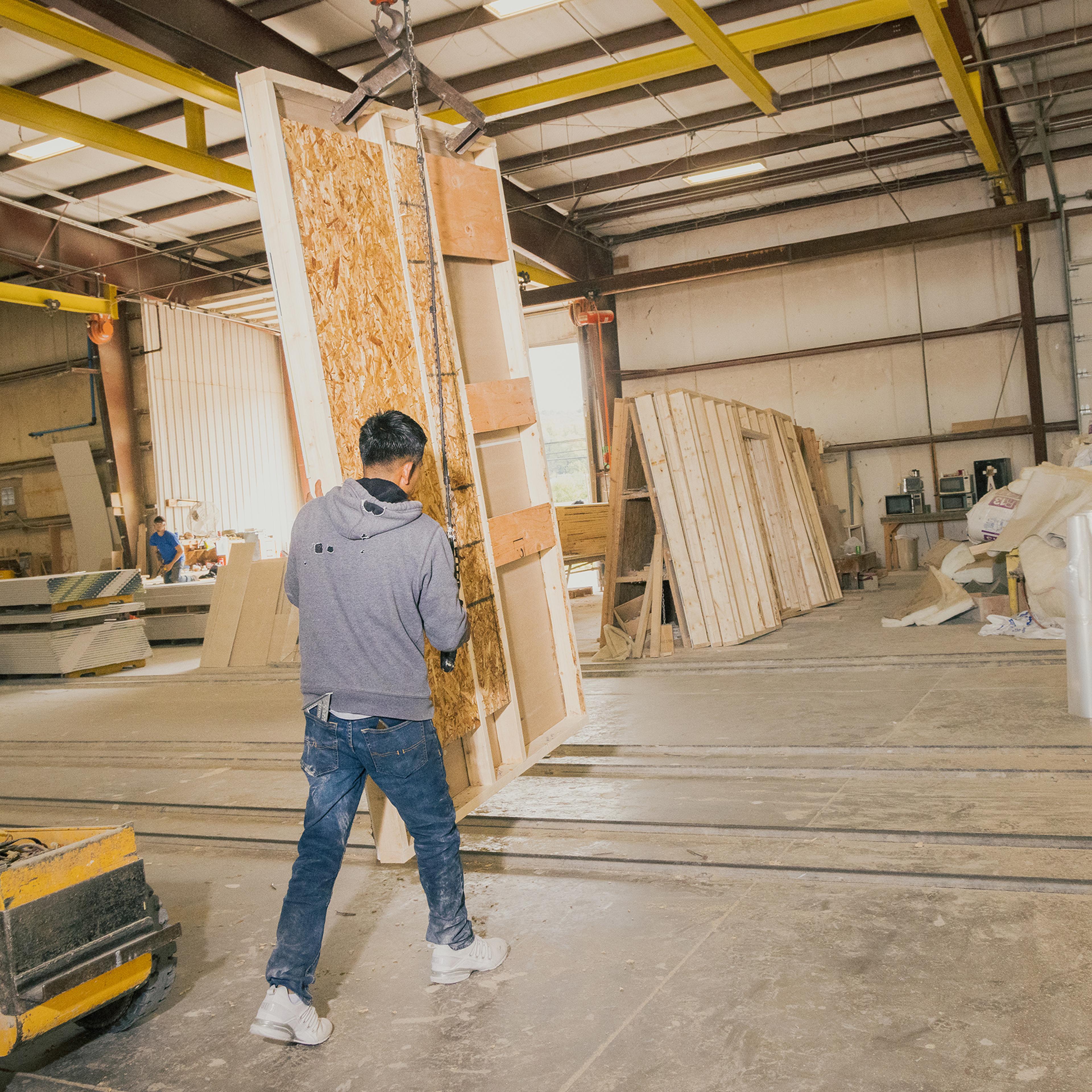 Moving a wall of the home from the production area to storage, to be used later on the rail system shown, in the factory of Apex Homes, in Middleburg, Pa. on Oct. 12.