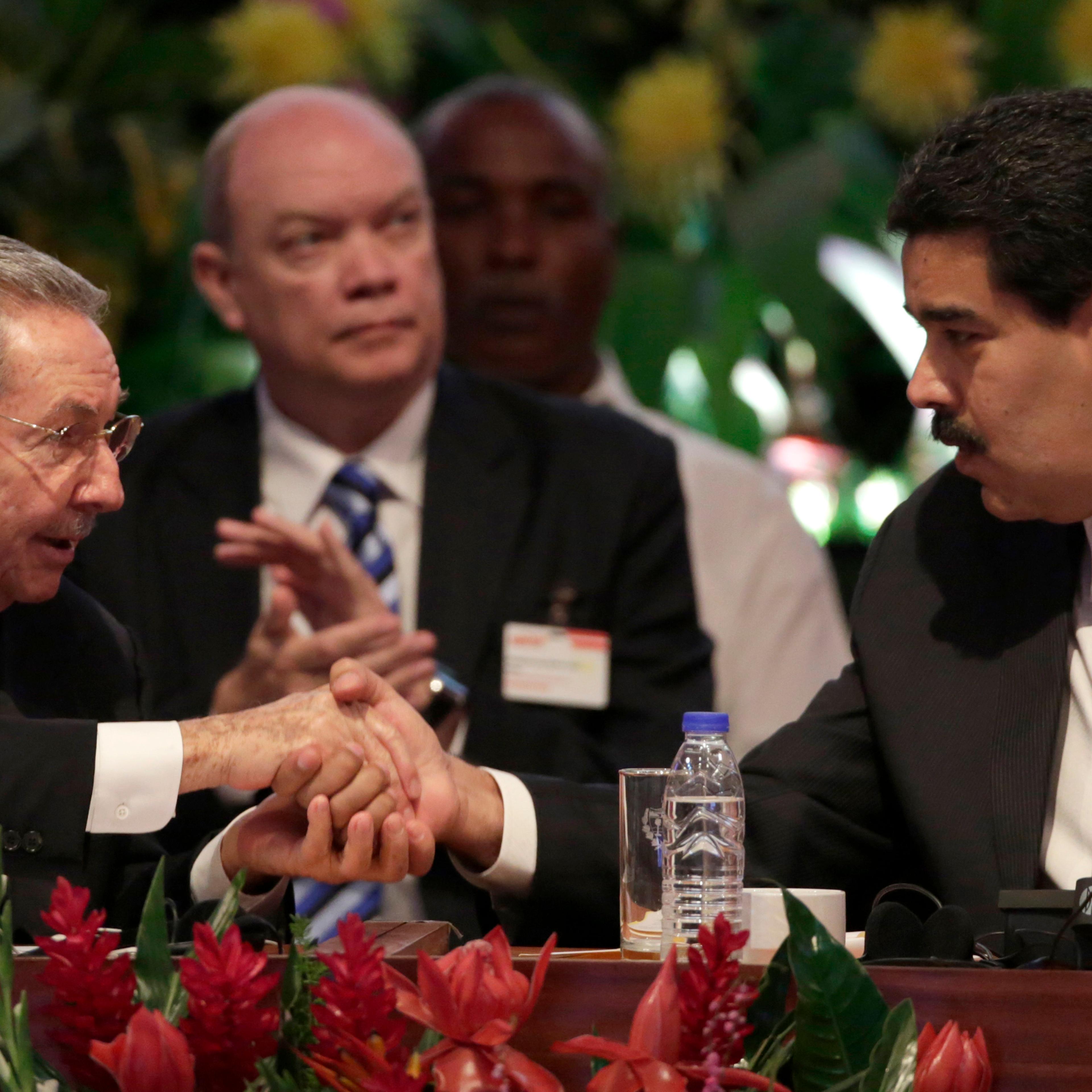 Cuba's President Raul Castro shakes hands with Venezuela's President Nicolas Maduro during the opening session of the 10th ALBA alliance summit in Havana
