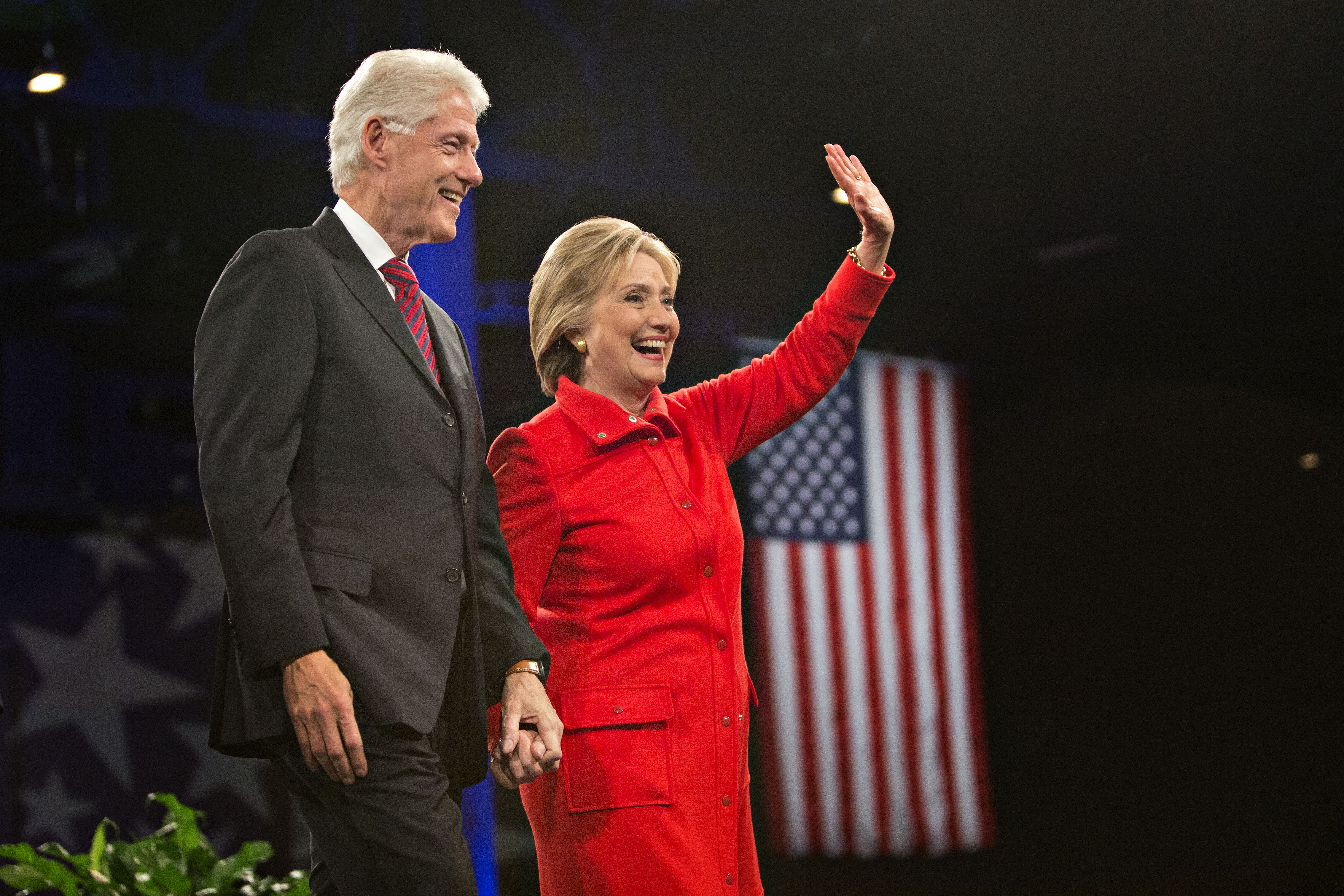 Hillary Clinton, former U.S. secretary of state and 2016 Democratic presidential candidate, right, stands on stage with husband Bill Clinton, former U.S. president, at the conclusion of the Jefferson-Jackson Dinner in Des Moines, Iowa, U.S., on Oct. 24, 