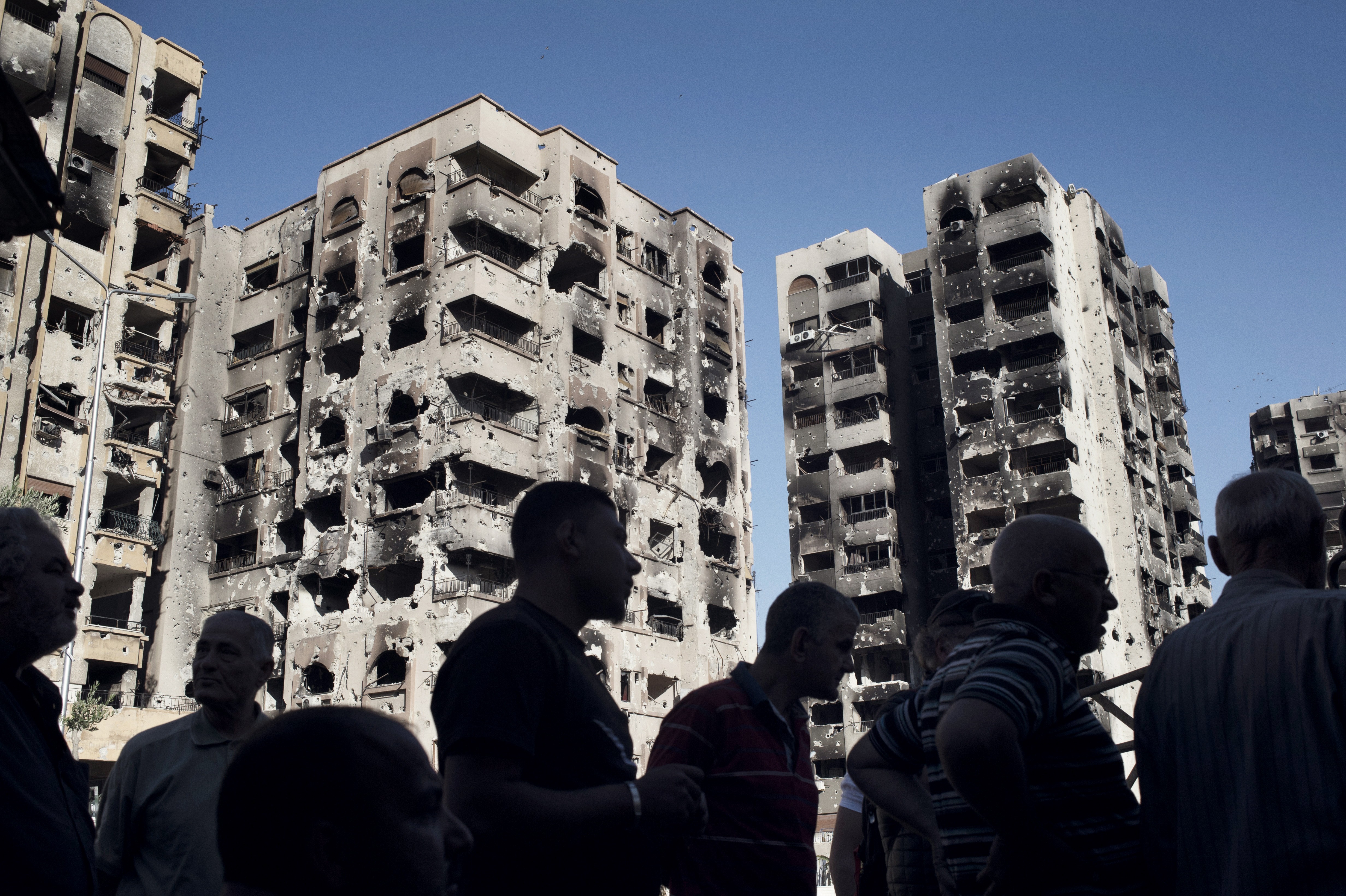 Men gather at a newly reopened mechanic's shop in the Barze neighborhood of Damascus on May 14, 2014.