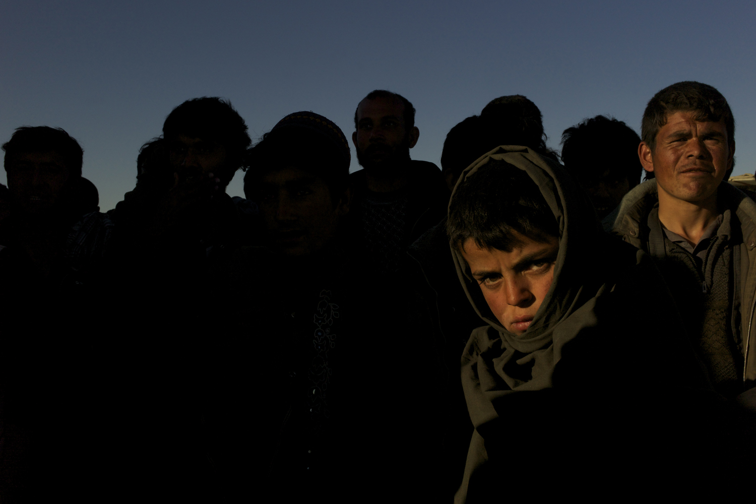 March, 2012. Abrishem, Afghanistan.<br /><br />Captured by Iranian soldiers while on the clandestine journey west with smugglers, 13-year-old Muhibullah has spent the last four nights in a detention centre. Deported back to Abrishem, Muhibullah stands on the windswept desert border, cold and tired. Searching out a cheap hotel for the night, like hundreds of others deported each day, the group is bound to seek out their smuggler once again. It will be a matter of days before they make the long and dangerous migration back to Iran.