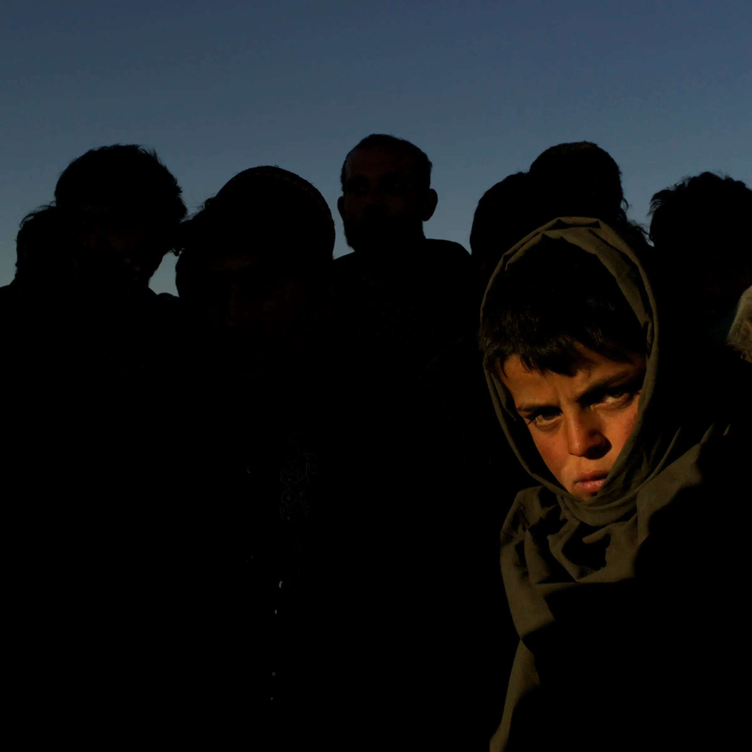 March, 2012. Abrishem, Afghanistan.<br /><br />Captured by Iranian soldiers while on the clandestine journey west with smugglers, 13-year-old Muhibullah has spent the last four nights in a detention centre. Deported back to Abrishem, Muhibullah stands on the windswept desert border, cold and tired. Searching out a cheap hotel for the night, like hundreds of others deported each day, the group is bound to seek out their smuggler once again. It will be a matter of days before they make the long and dangerous migration back to Iran.