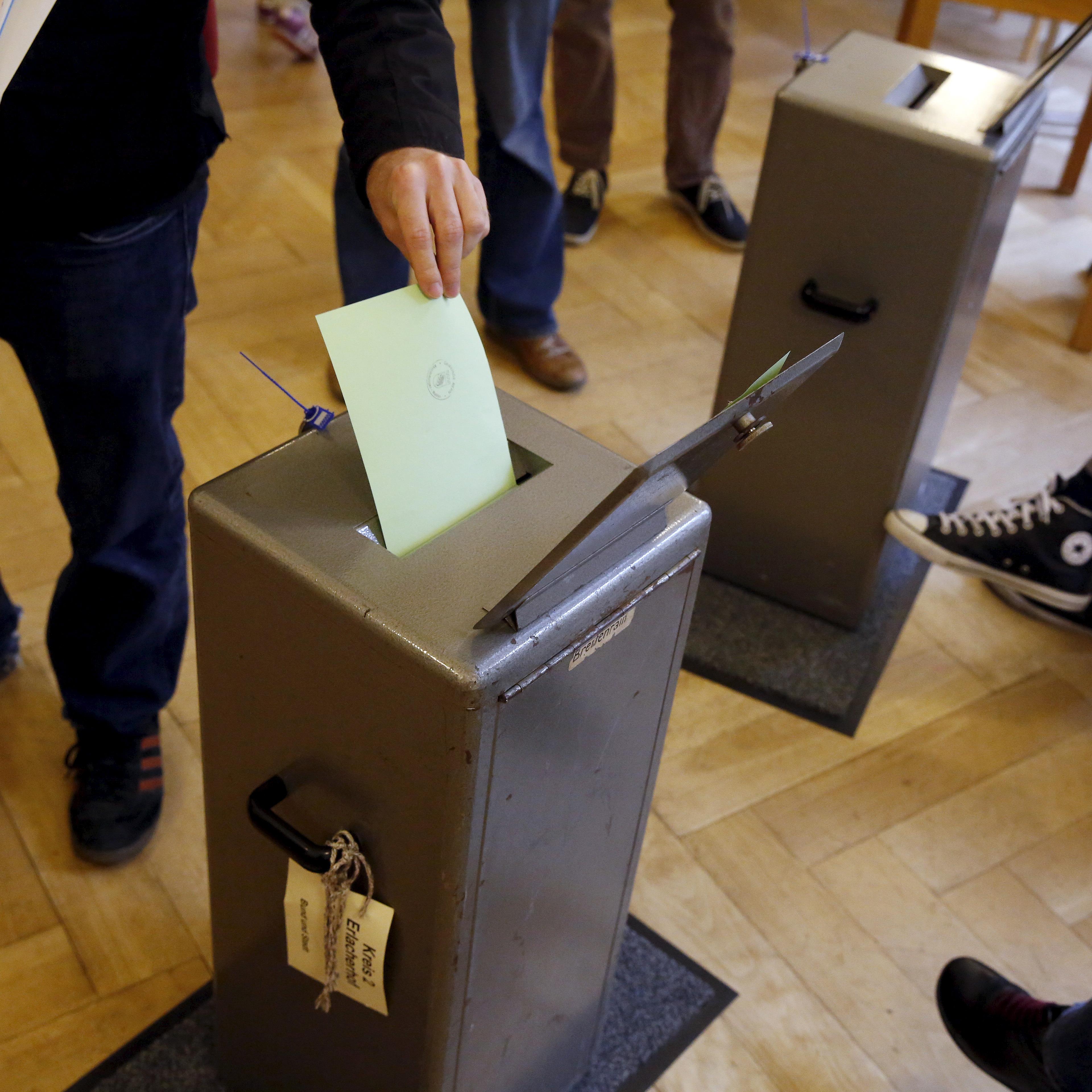 People cast their vote in a school house in Bern