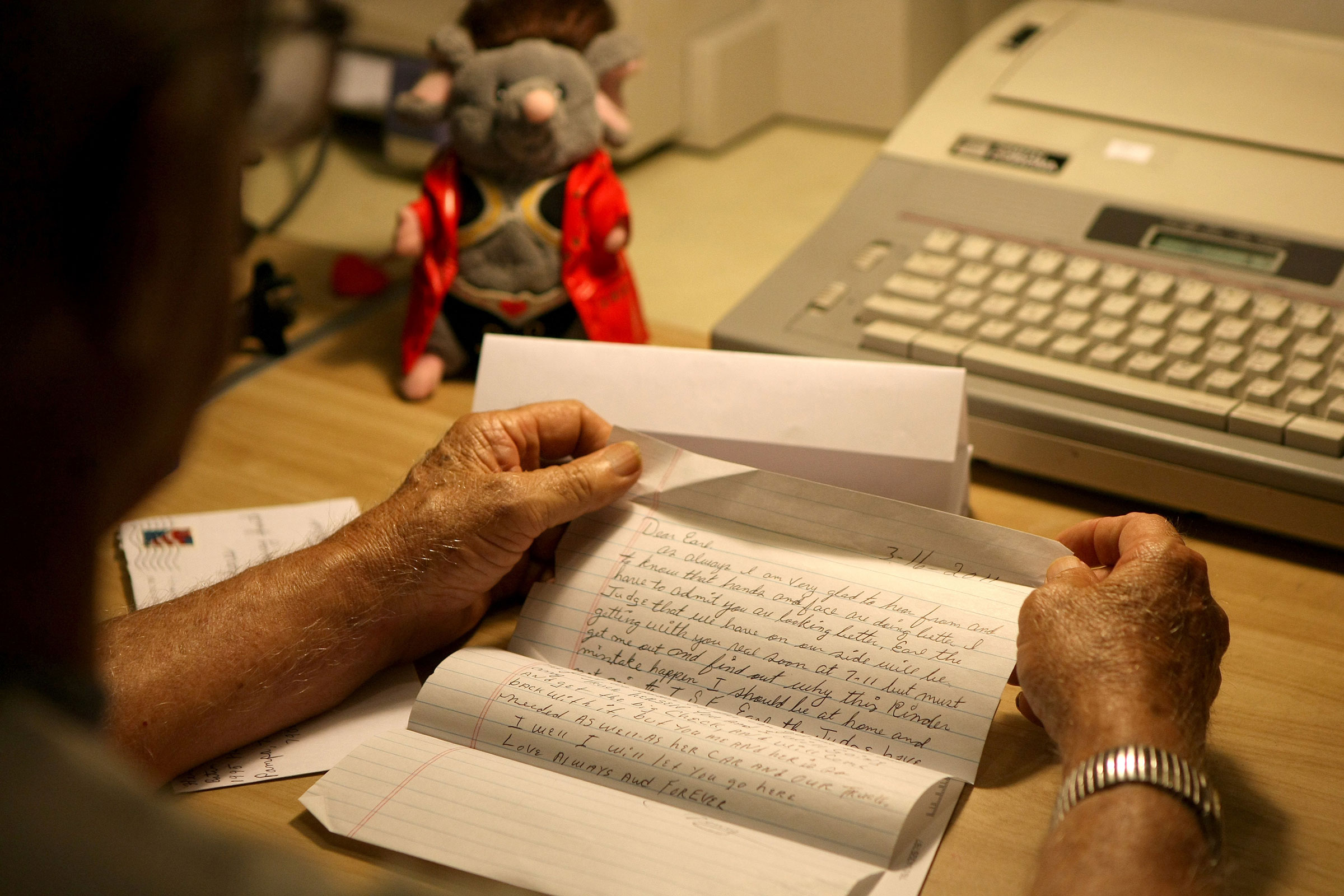 a letter written to an inmate in prison, held in a man’s hands