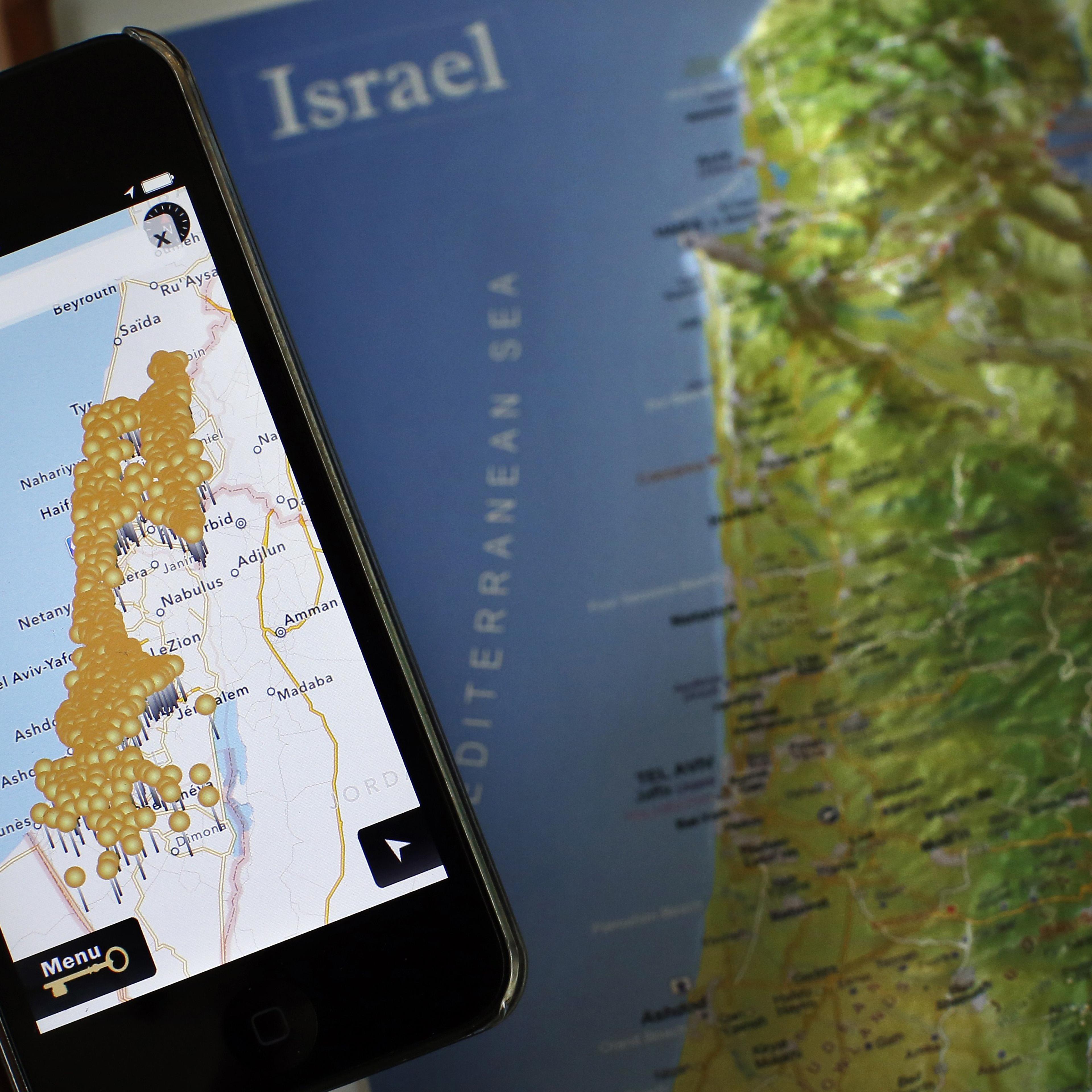 A smartphone placed on an Israeli map in Jerusalem, displaying the new iNakba application that allows users to find the remains of Palestinian villages that now lie inside modern-day Israel, May 5, 2014.