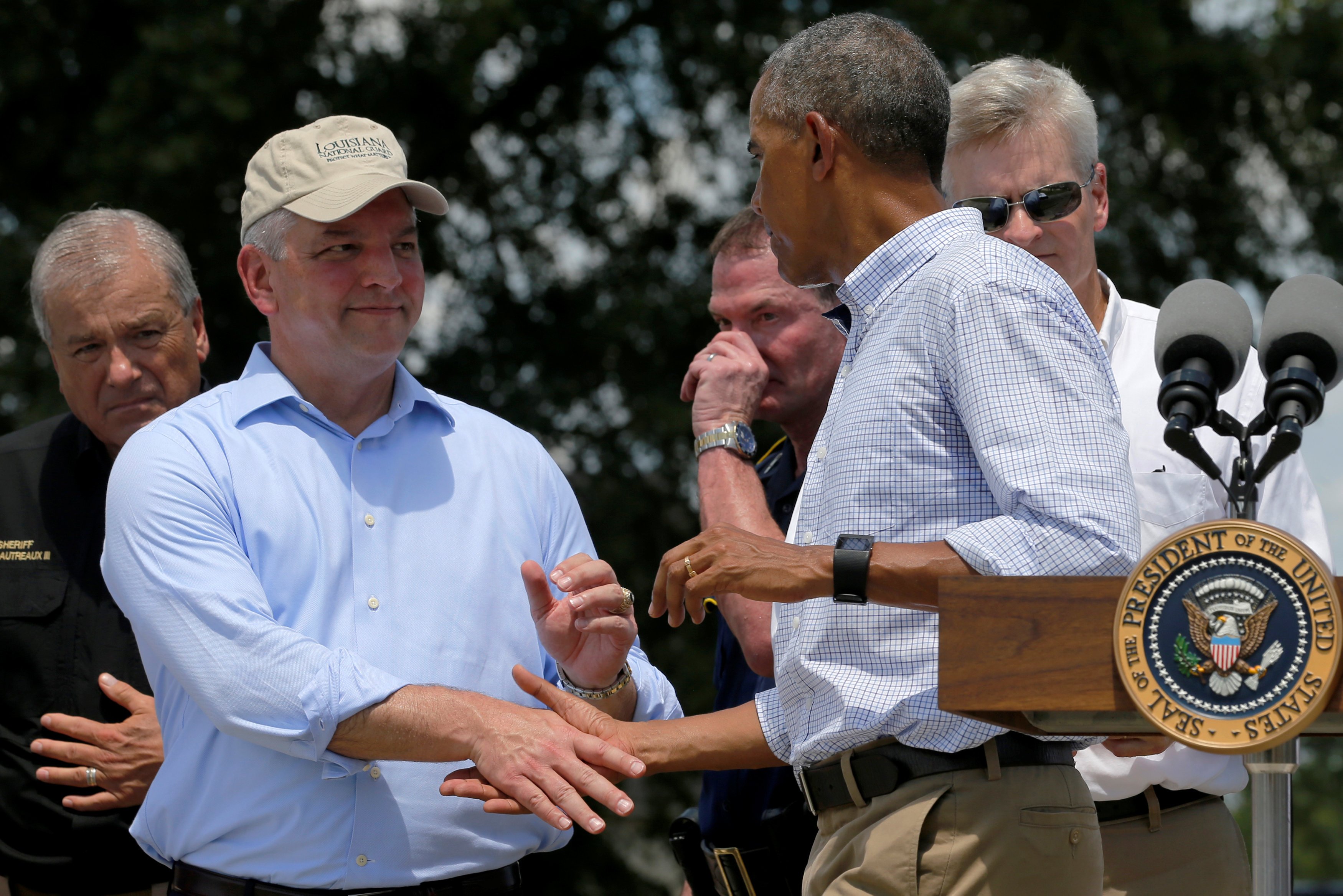 Louisiana Governor John Bel Edwards shakes hands with U.S. President Barack Obama after his remarks following a tour of a flood-affected neighborhood in Zachary