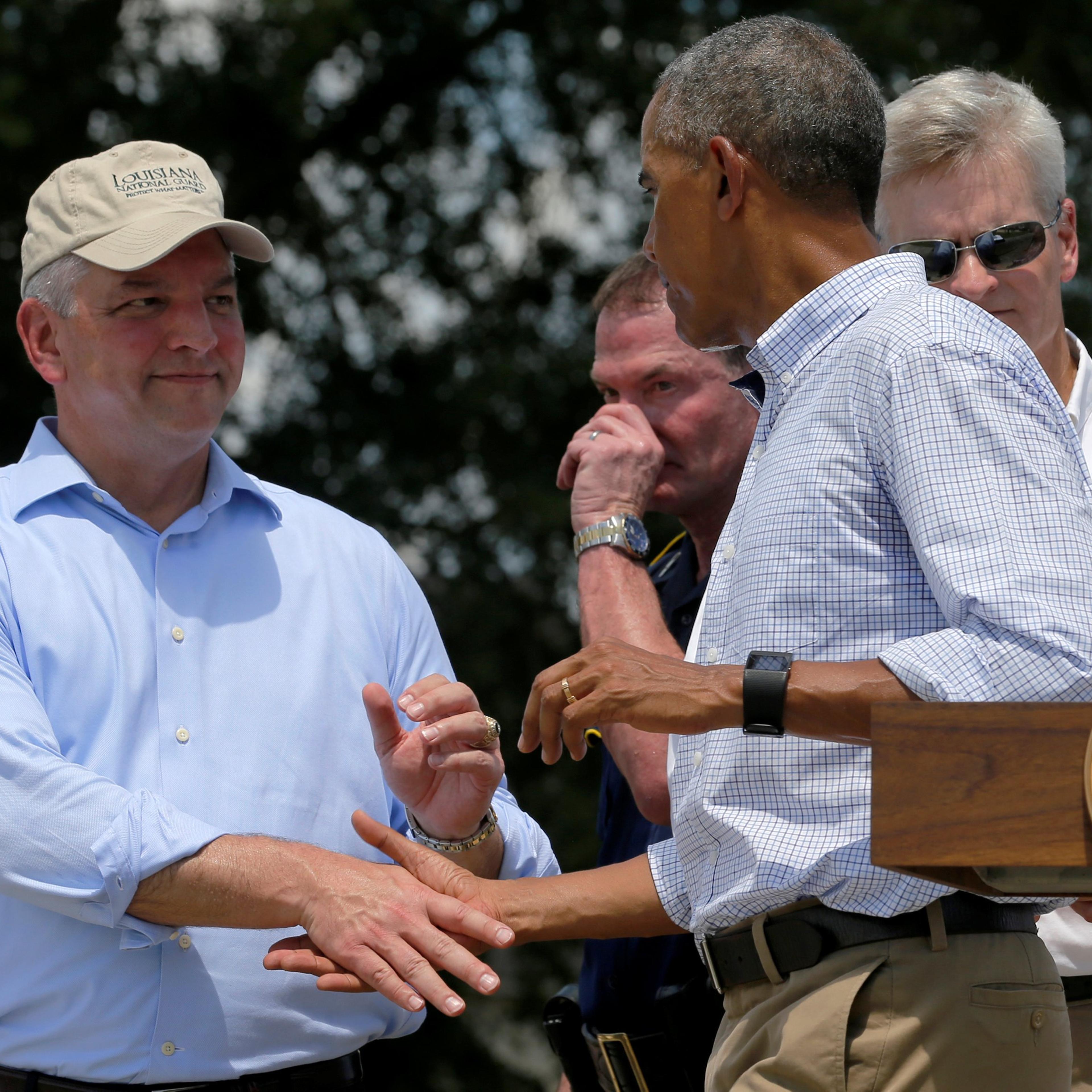 Louisiana Governor John Bel Edwards shakes hands with U.S. President Barack Obama after his remarks following a tour of a flood-affected neighborhood in Zachary