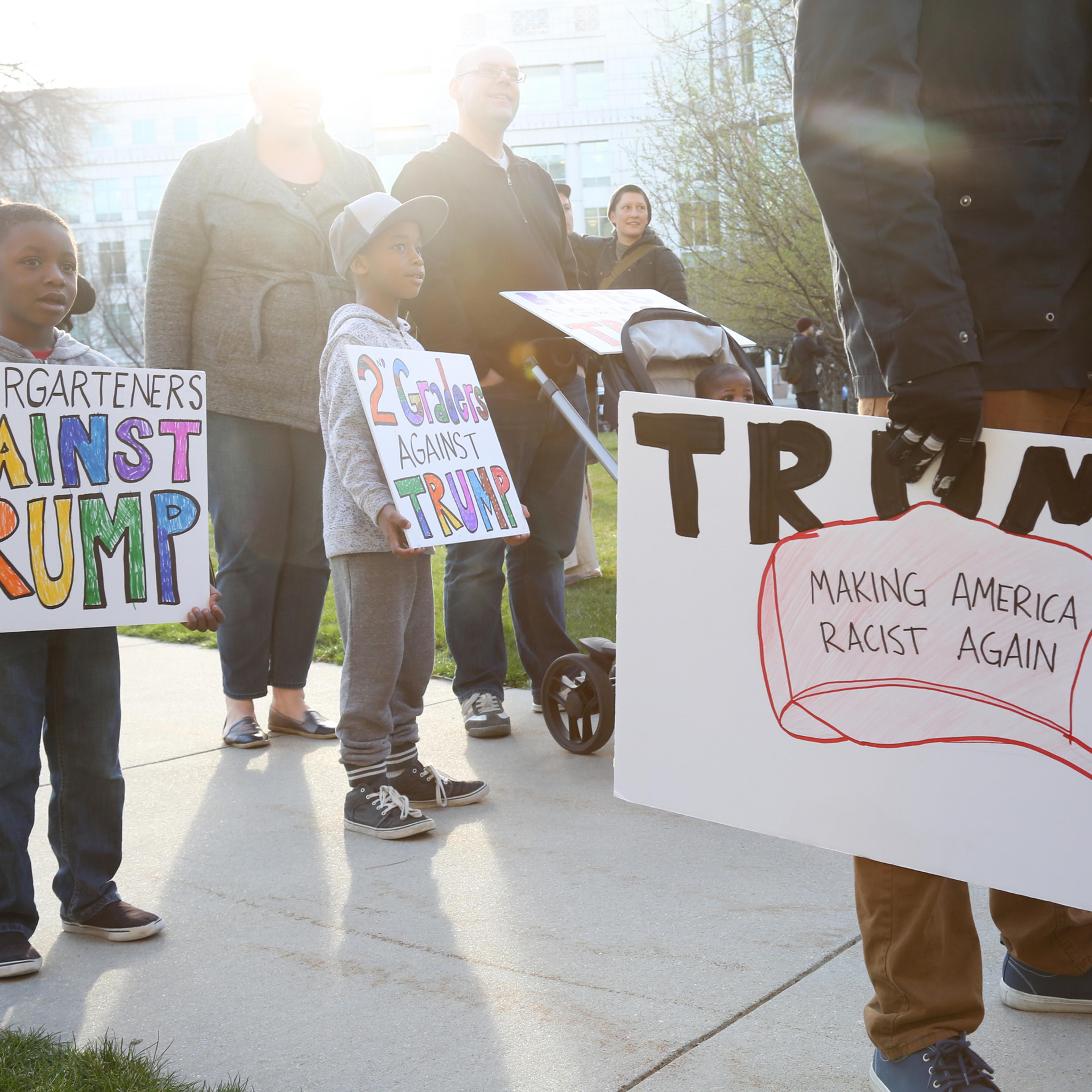 Brothers Noah, left and Owen Burket hold signs as they protest with their family at a rally outside the Infinity Events Center in Salt Lake City, where Republican Presidential candidate Donald Trump held a campaign rally on March 18, 2016.