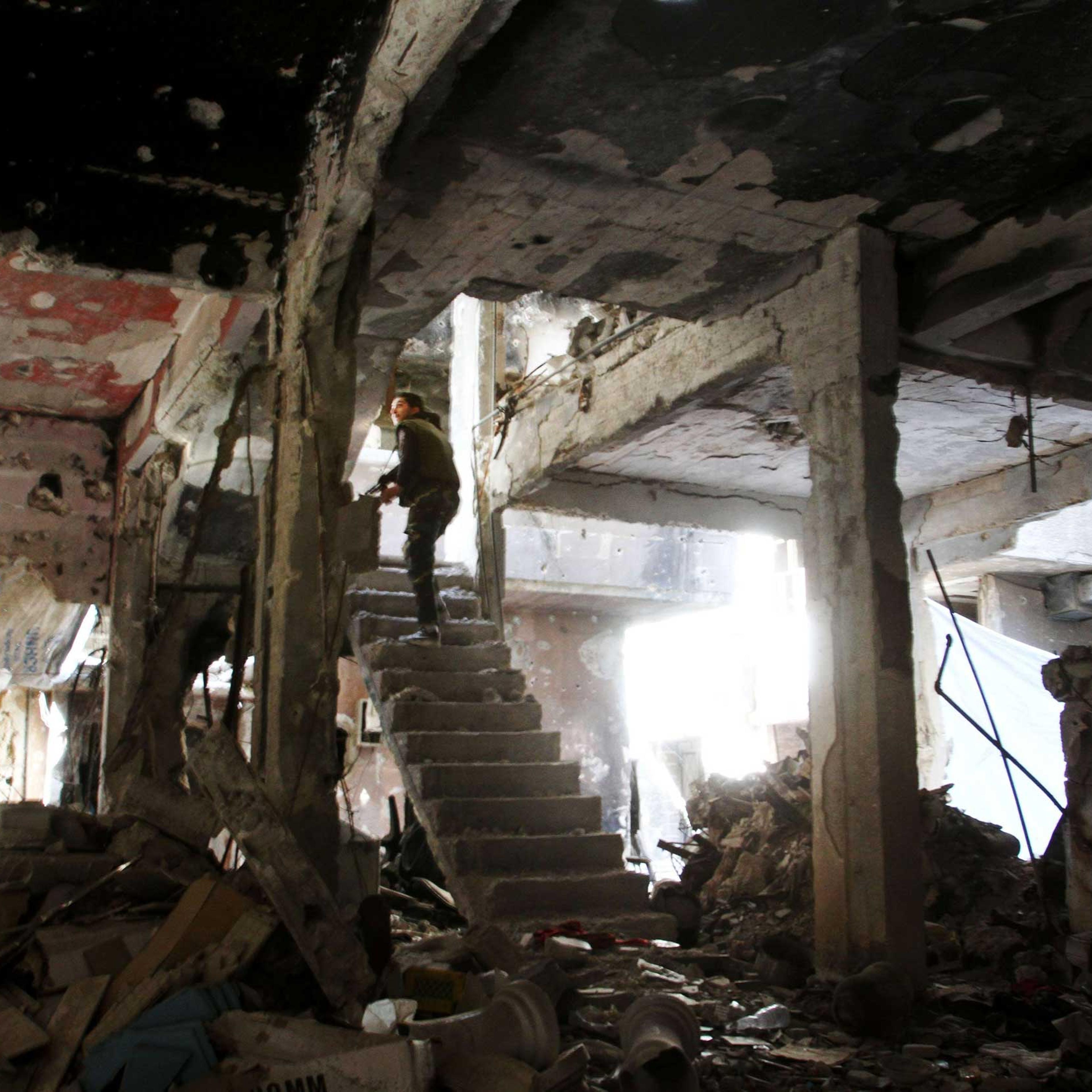 A man stands on a staircase inside a demolished building in the Yarmuk Palestinian refugee camp in the Syrian capital Damascus on April 6, 2015.