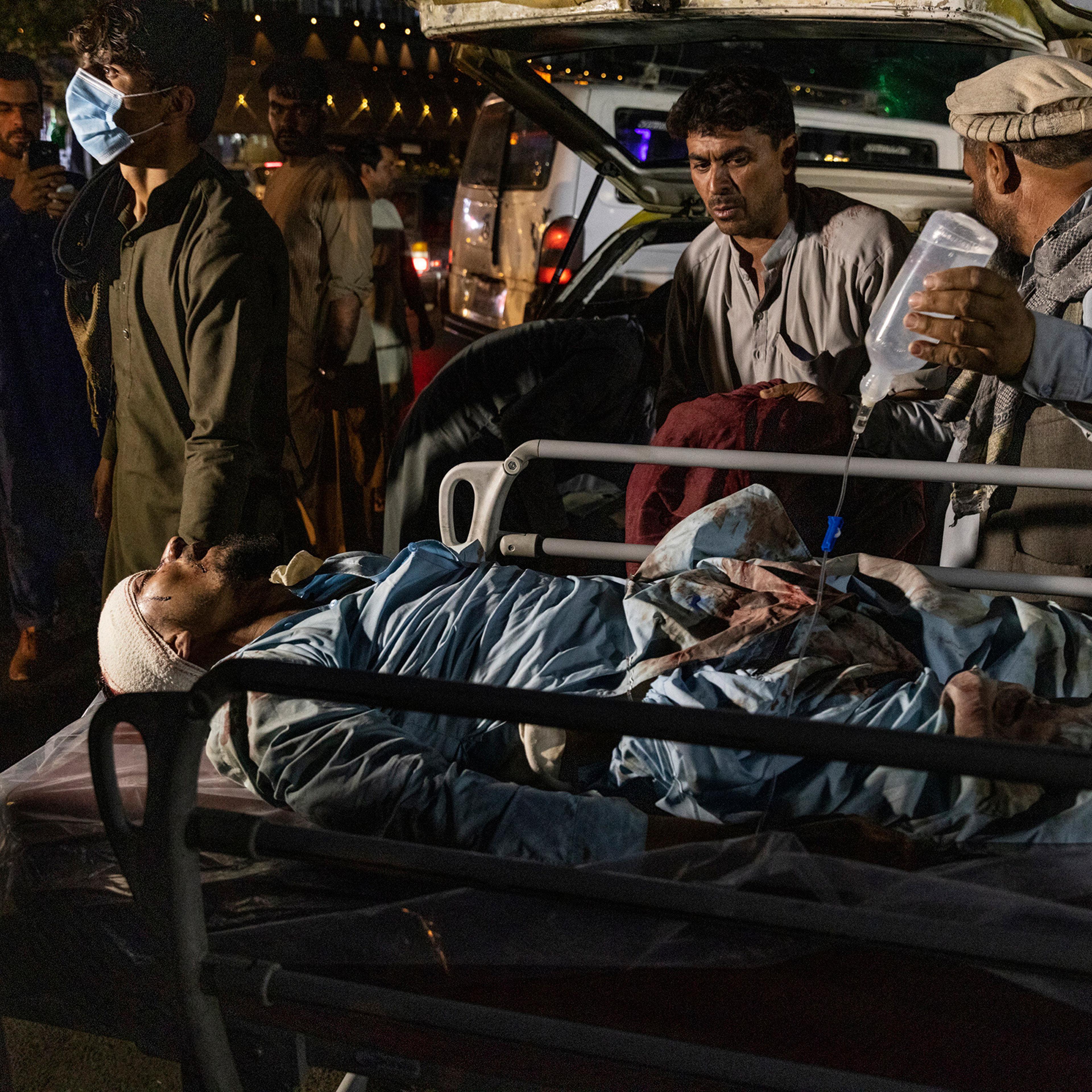 A wounded person is transported outside the international airport in Kabul on Aug. 26.