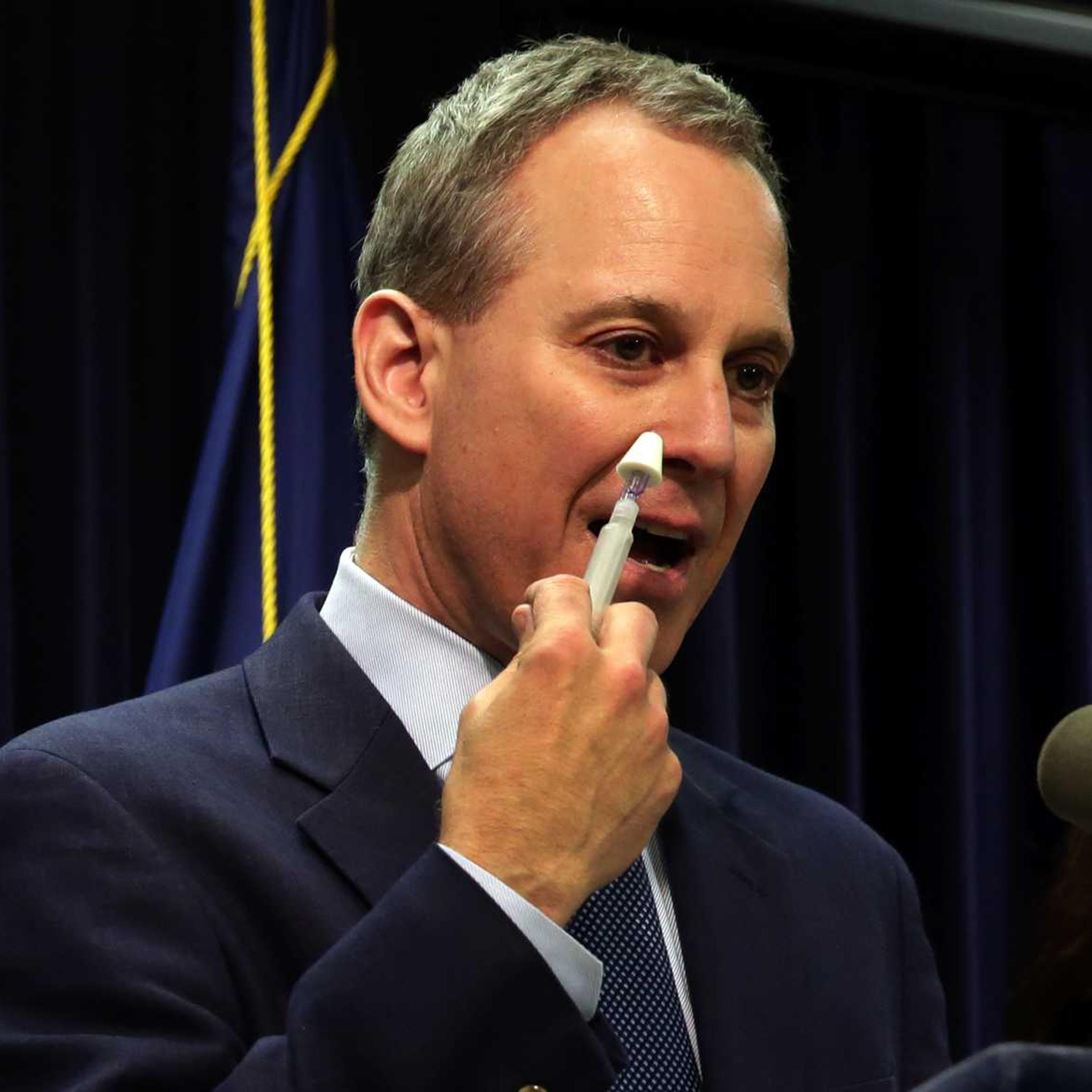 New York State Attorney General Eric Schneiderman demonstrates an inhaler of naloxone, a drug to be included in an overdose-prevention rescue kit, during a news conference in New York City on May 27, 2014