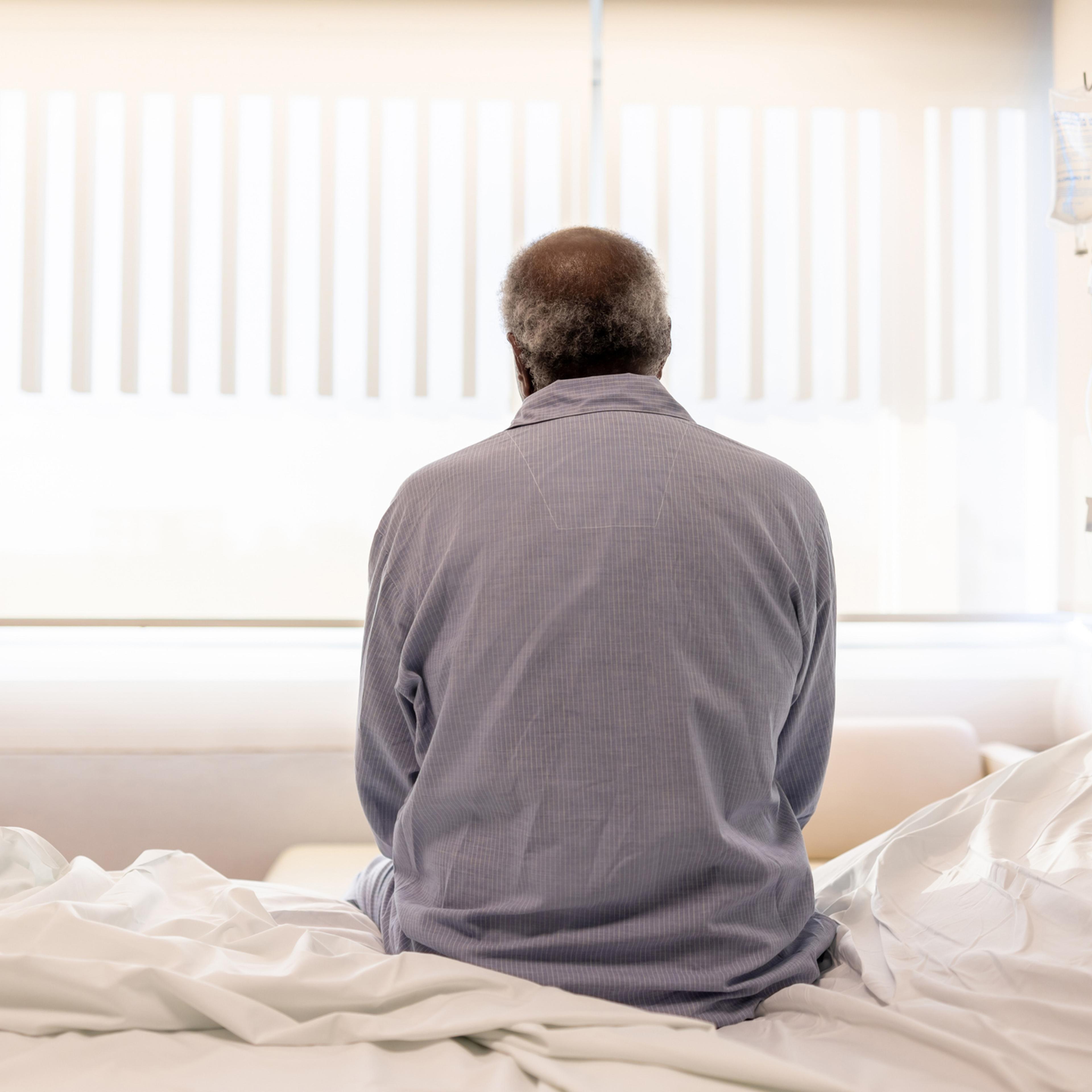 Sick man sitting on the bed at the hospital