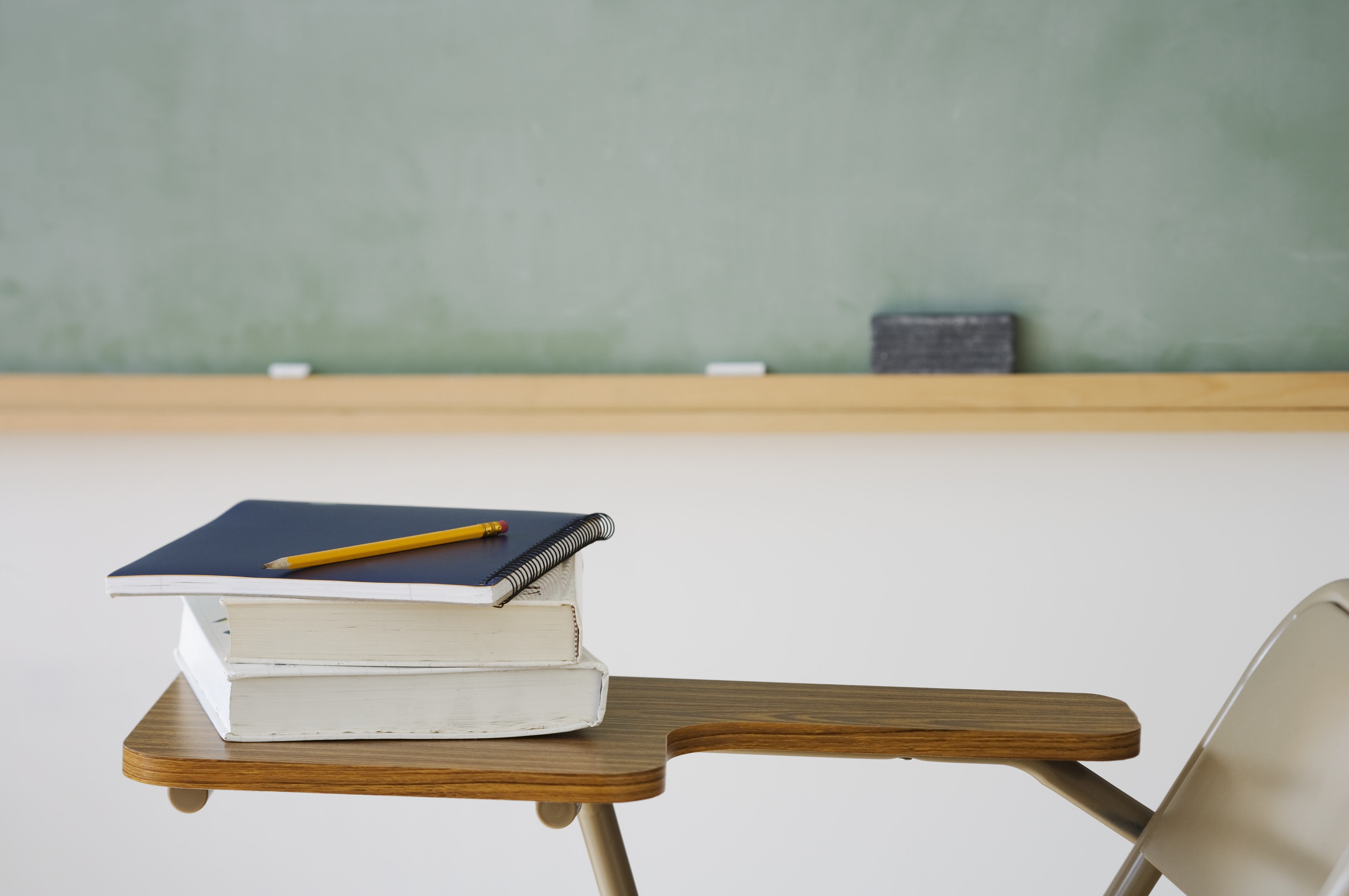 Books and pencil on desk in classroom