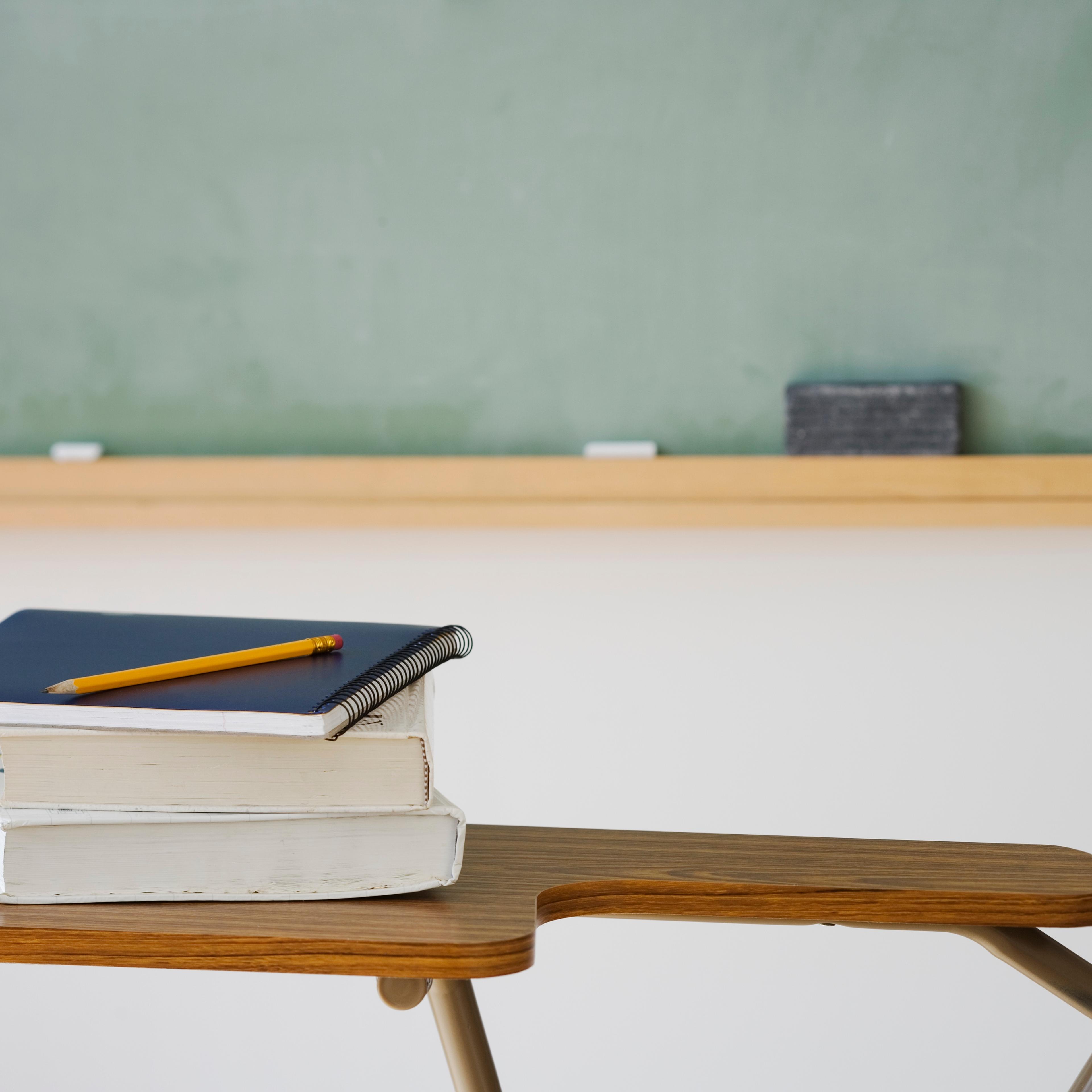 Books and pencil on desk in classroom