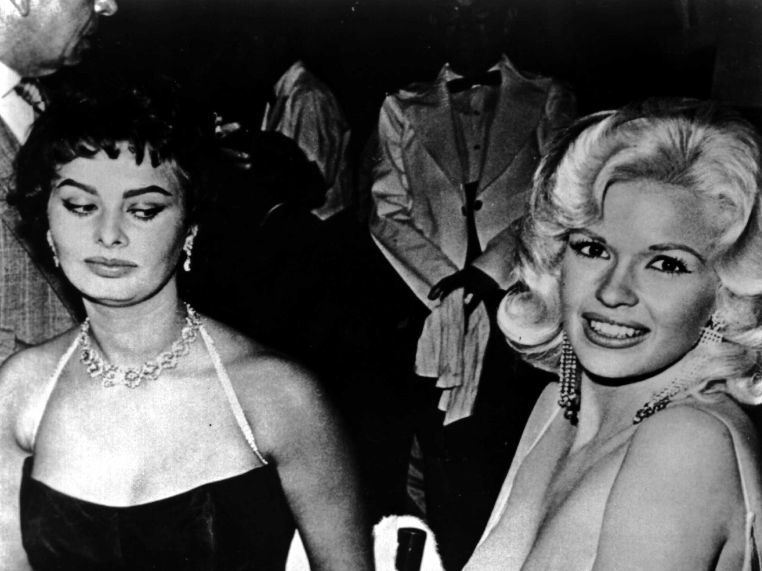 Jayne Mansfield tries to steal the show in a very low cut dress at a party thrown by 20th Century-Fox for Sophia Loren on April 12, 1957 in Los Angeles.