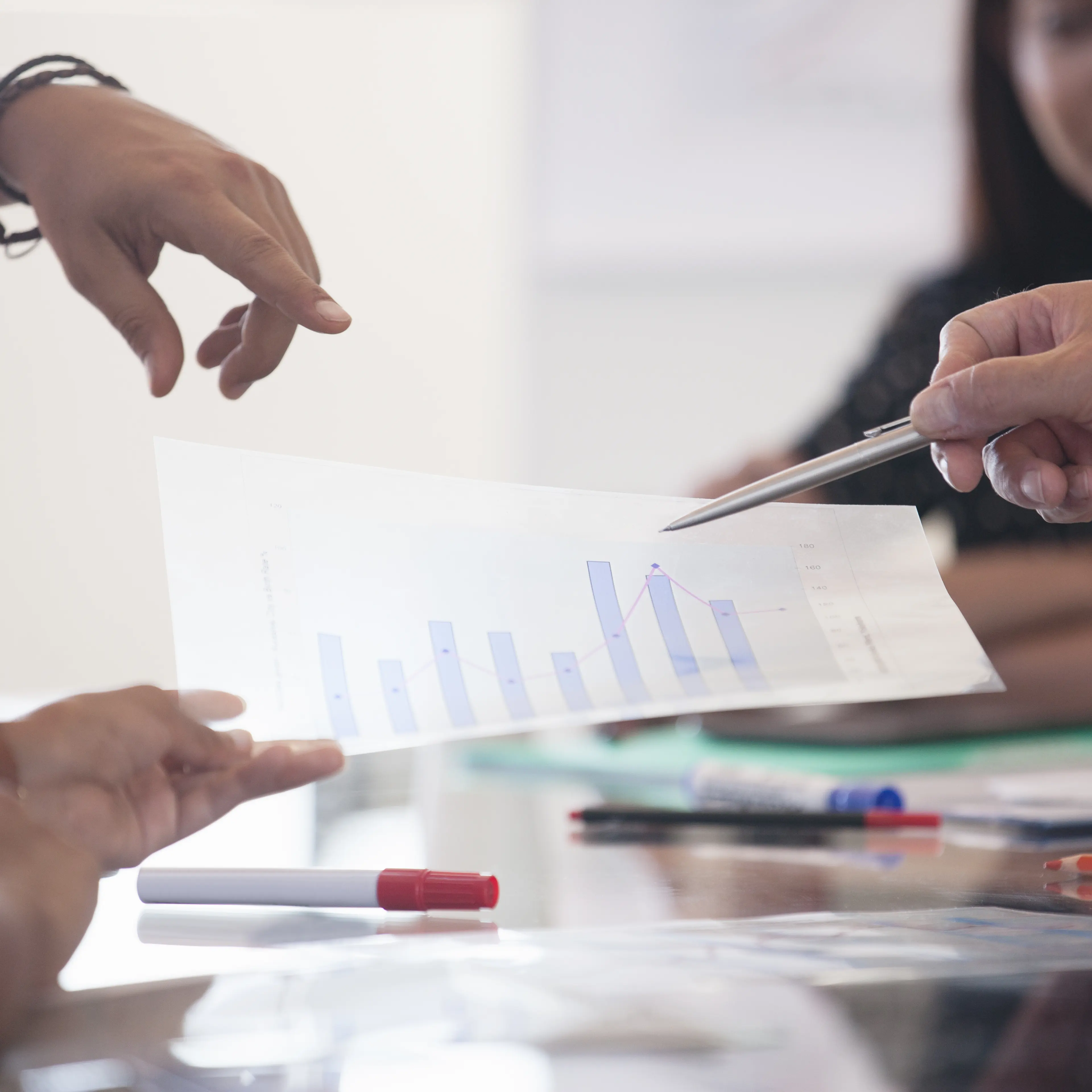 Business people pointing at graph in meeting