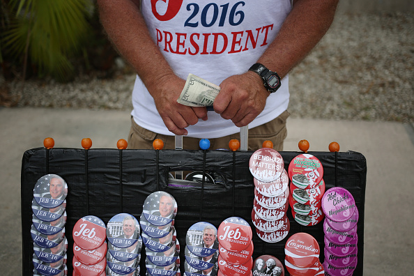 A vendor holds money while selling buttons and t-shirts outside an event where Former Governor of Florida Jeb Bush announced he will seek the 2016 Republican presidential nomination on the Kendall Campus of Miami Dade College in Miami, Florida, U.S., on 