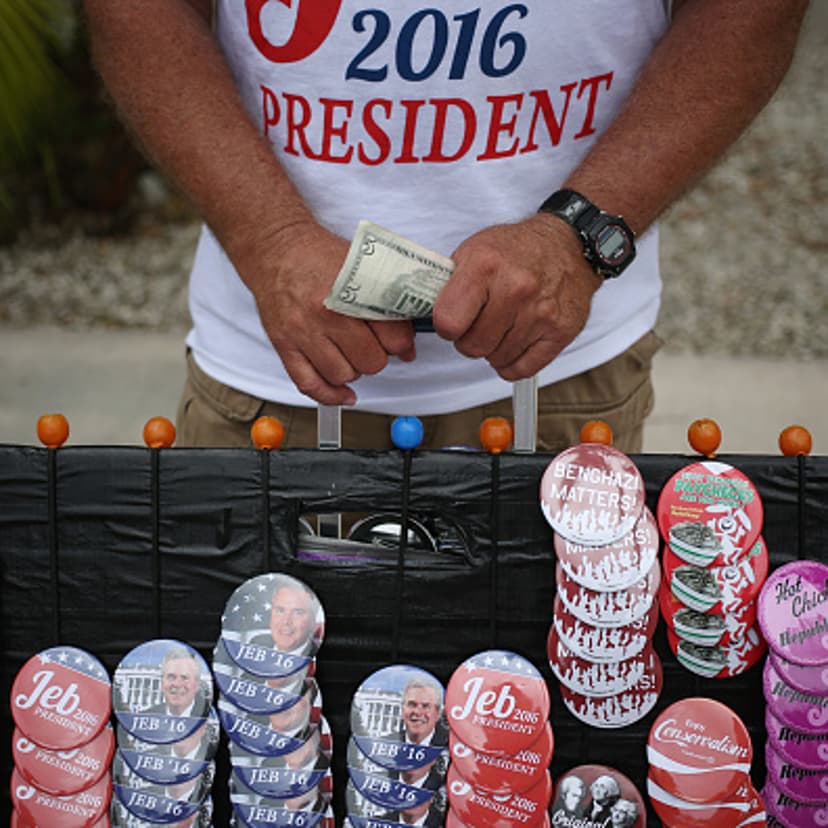 A vendor holds money while selling buttons and t-shirts outside an event where Former Governor of Florida Jeb Bush announced he will seek the 2016 Republican presidential nomination on the Kendall Campus of Miami Dade College in Miami, Florida, U.S., on