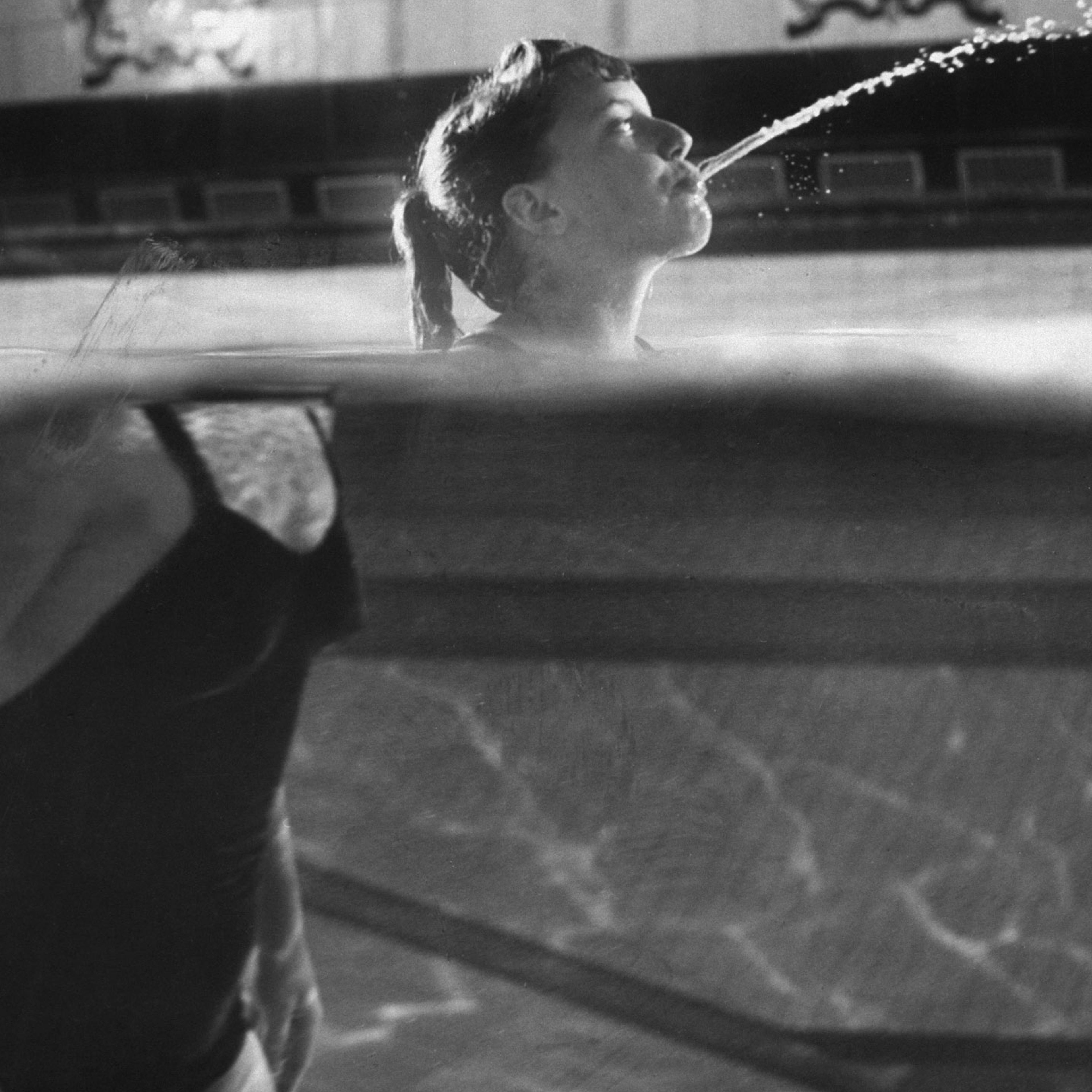 Swimmer Kathy Flicker spits water in a swimming pool in 1962.