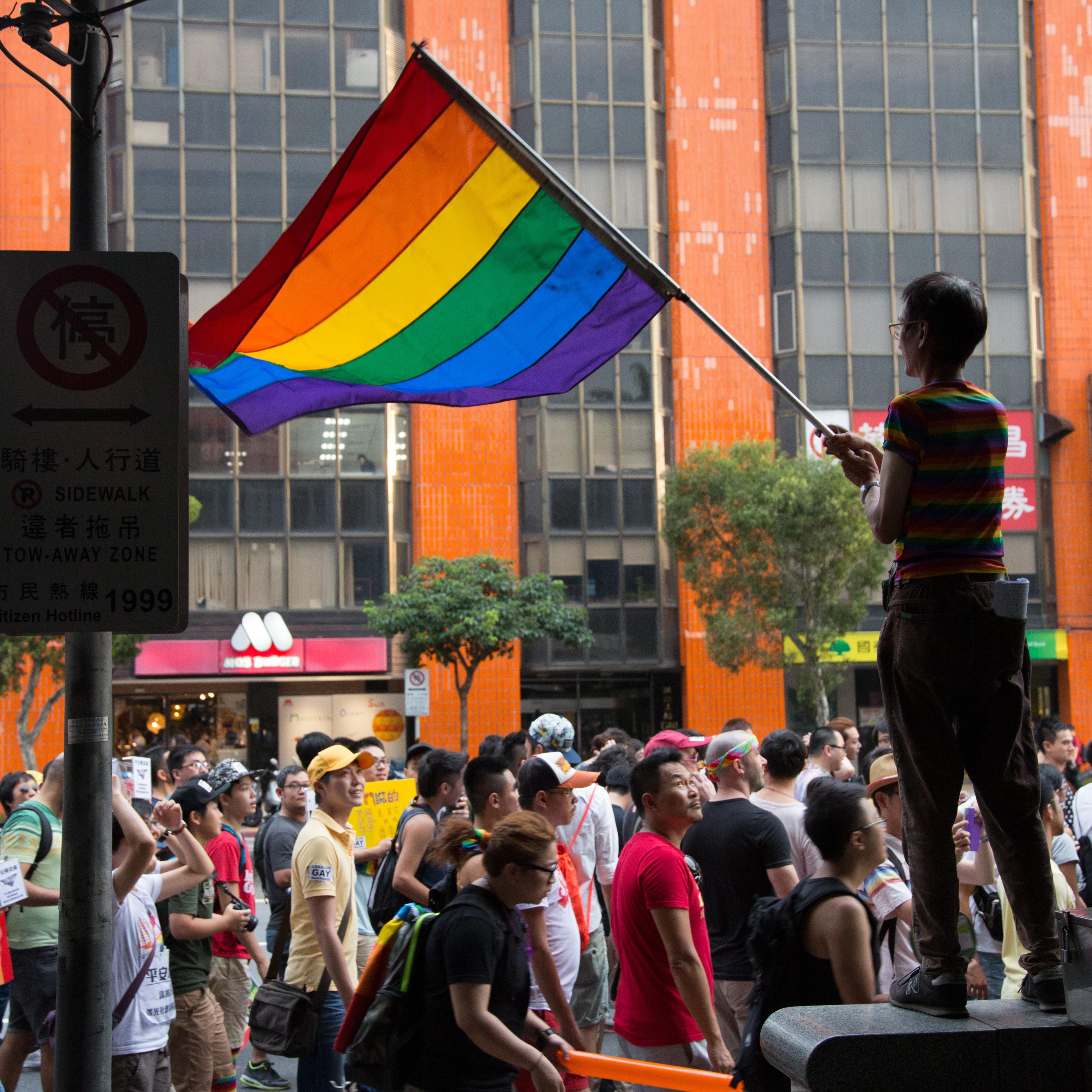 A man waves the LGBT rainbow flag in support of gay marriage