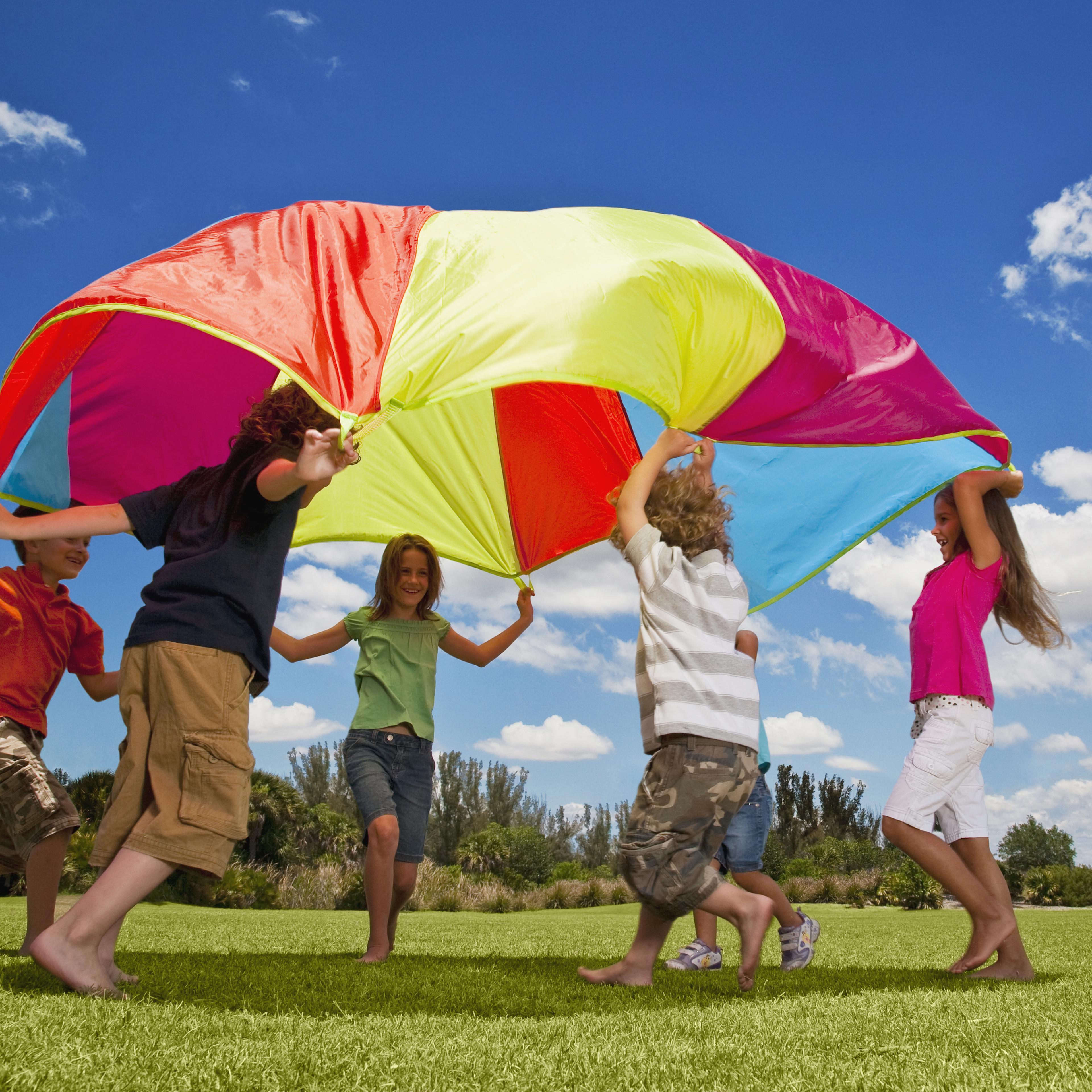 Group of kids playing with a parachute in the park