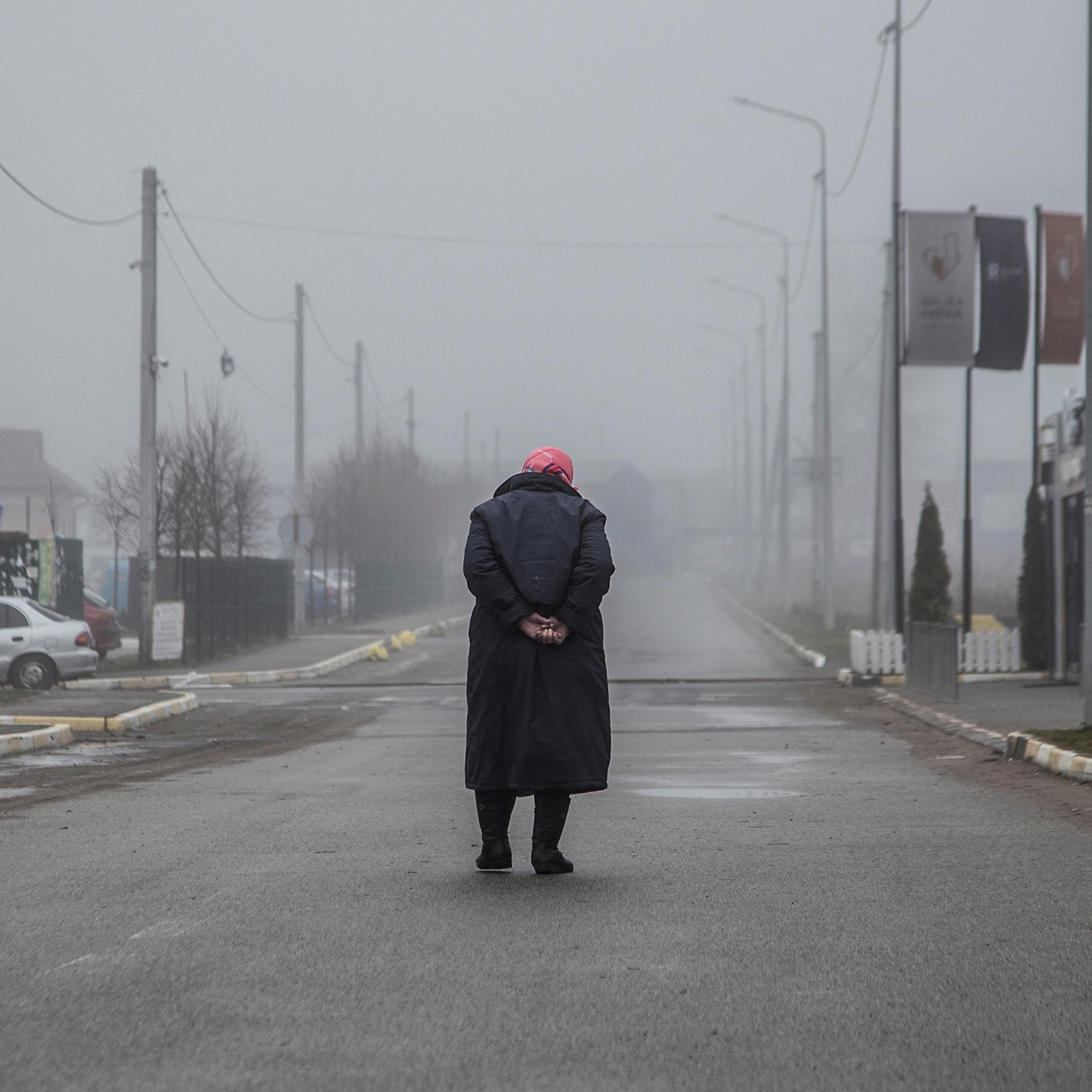A woman walks along an empty street in Bucha, Ukraine, April 1, 2022.