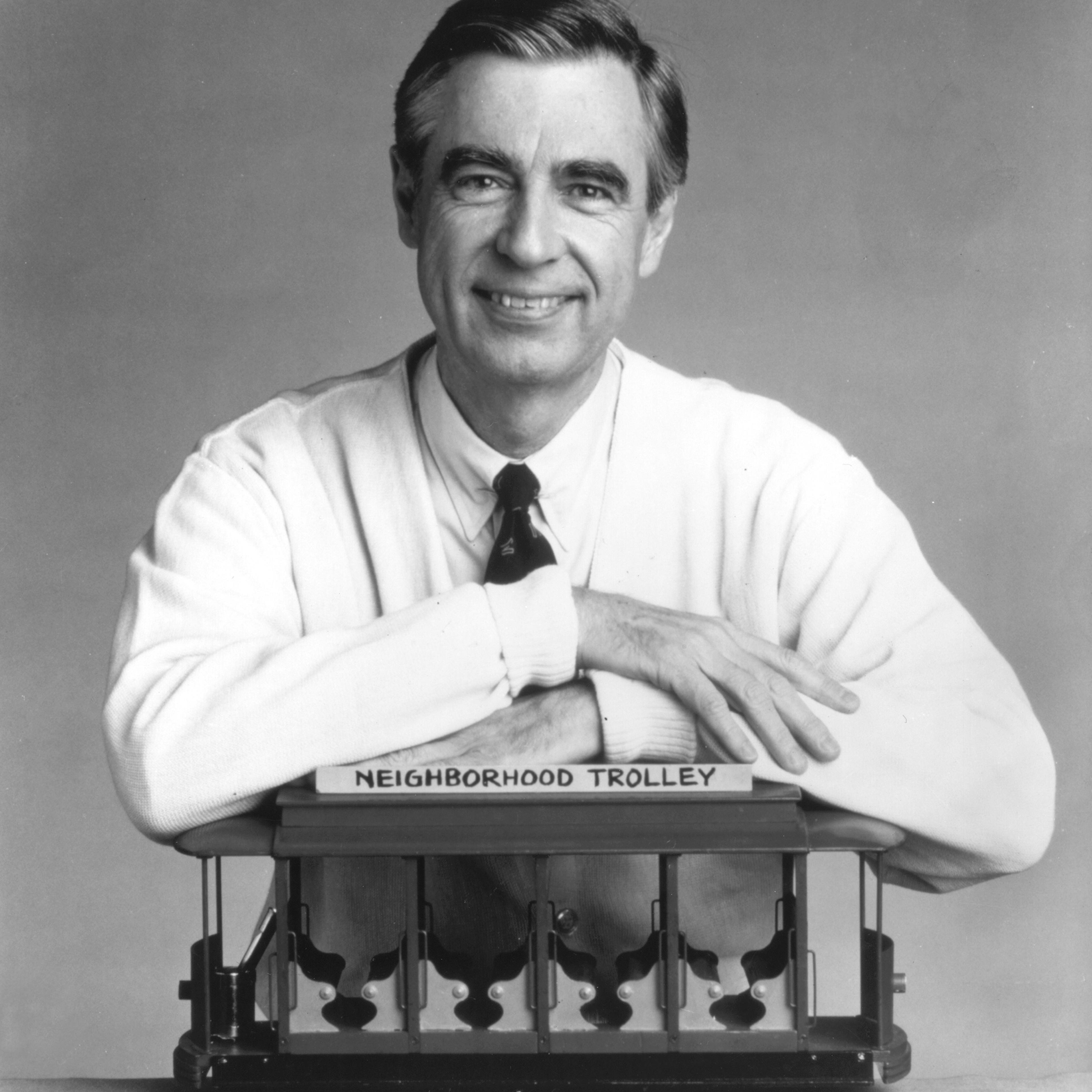 Fred Rogers, the host of the children's television series, "Mr. Rogers' Neighborhood," rests his arms on a small trolley in this promotional portrait from the 1980's.