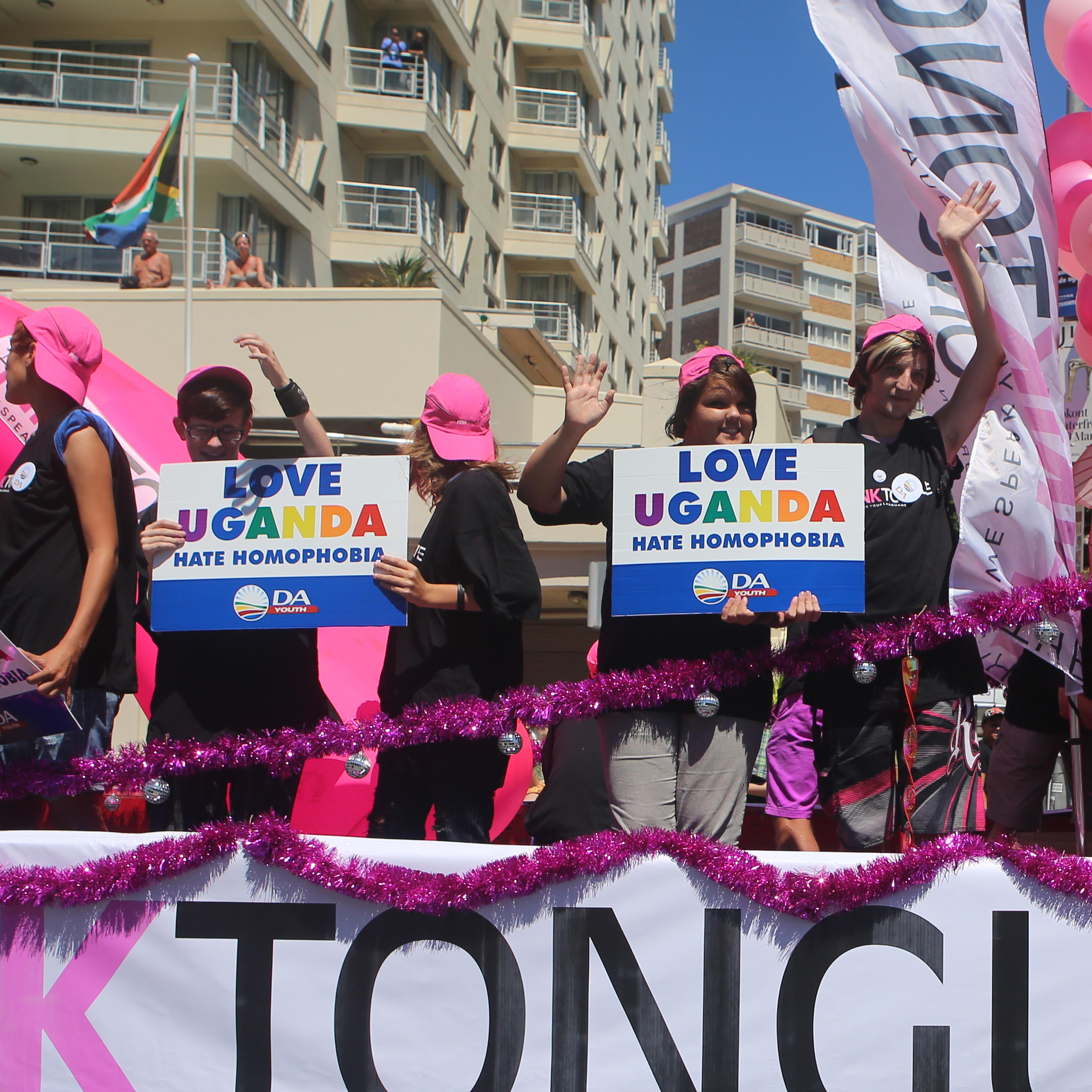 People stand on a float holding signs saying 'Love Uganda, hate homophobia' in reaction to Uganda's law banning homosexuality in Cape Town, South Africa, on March 1, 2014.