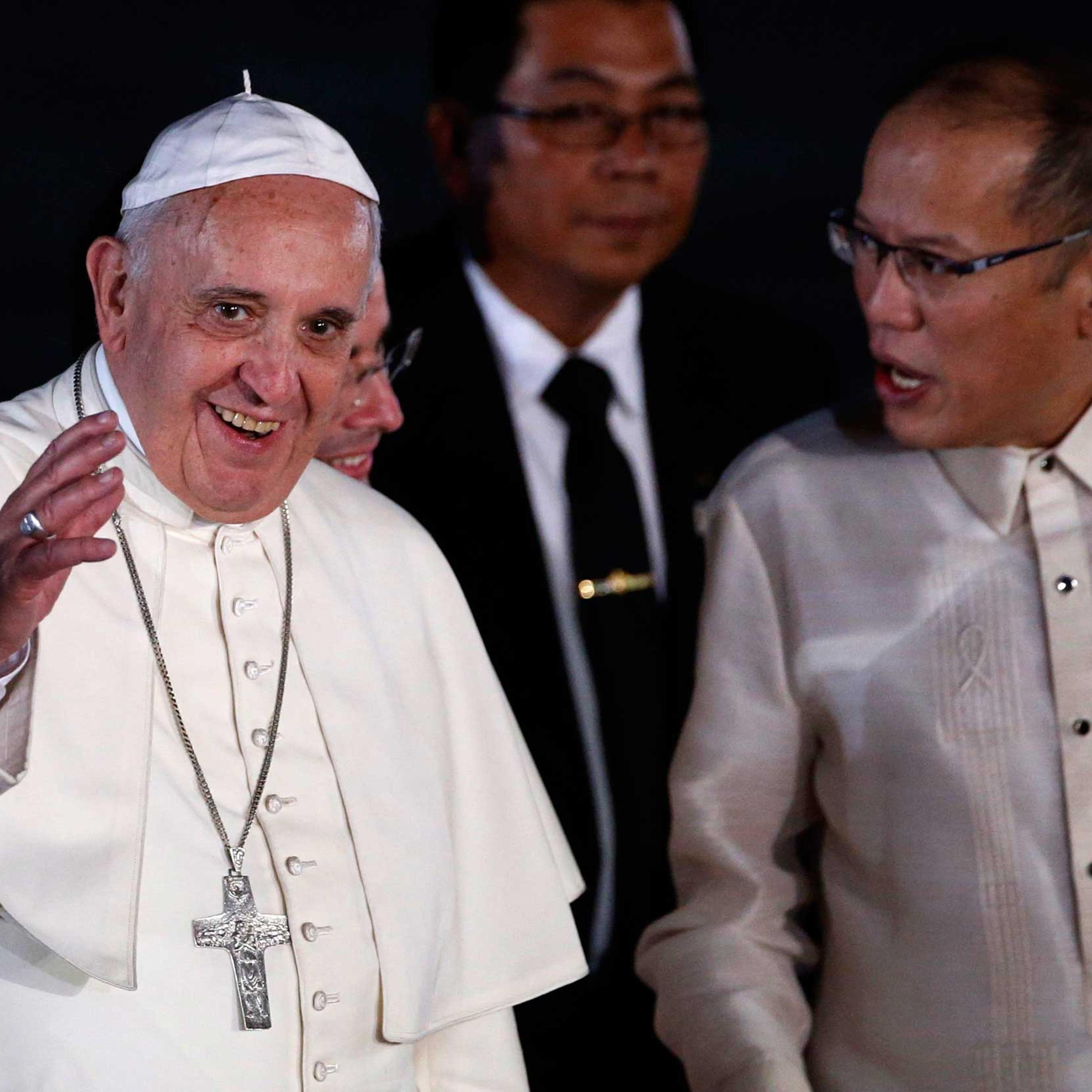 Pope Francis waves to the crowd next to President Aquino upon his arrival at Villamor Air Base in Manila