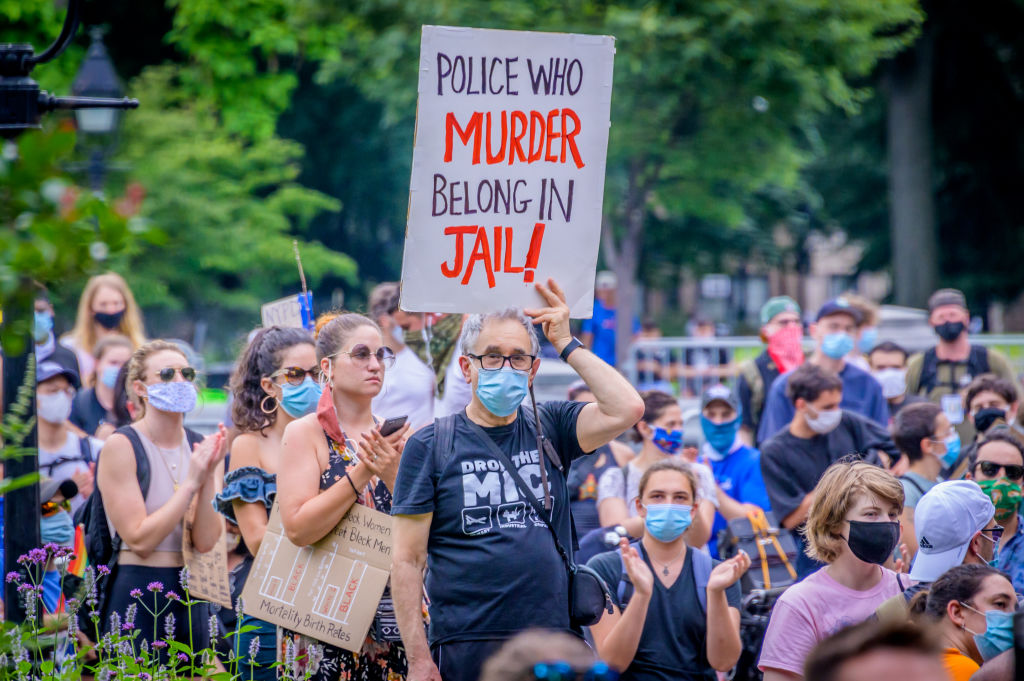 A participant holding a sign at the protest. On the eve of