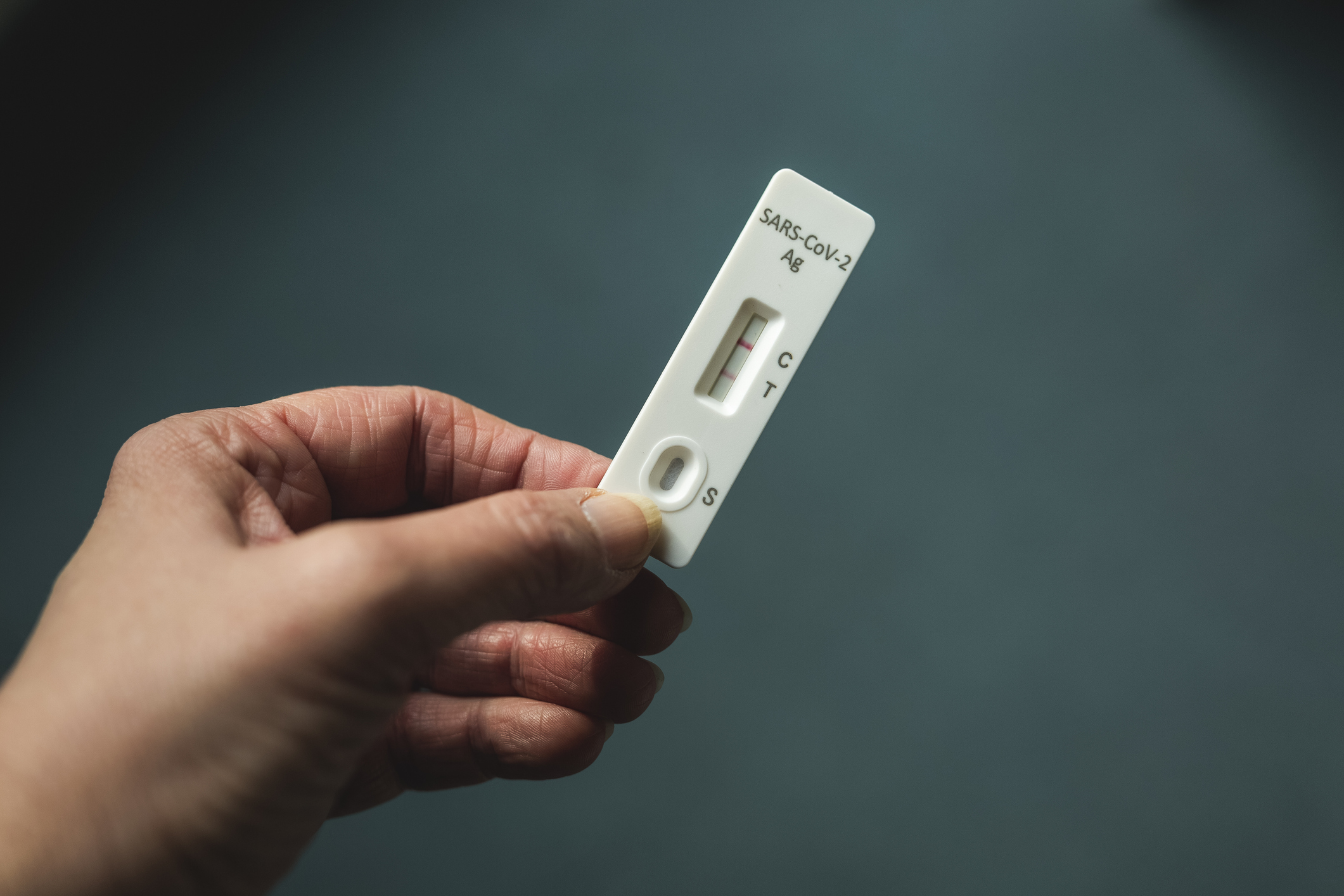 Hand of woman holding rapid diagnostic test for COVID-19