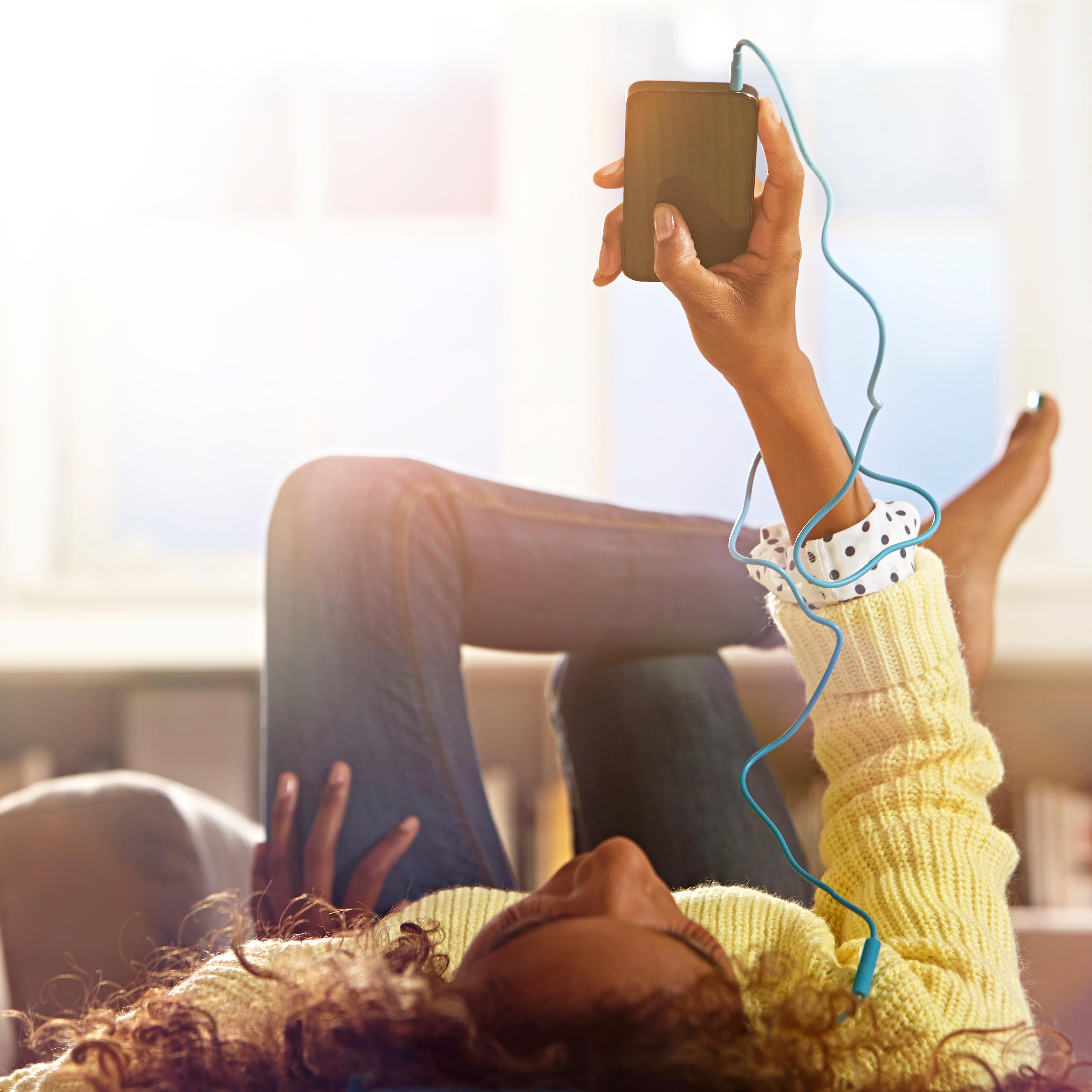 Woman relaxing at home listening to her phone.