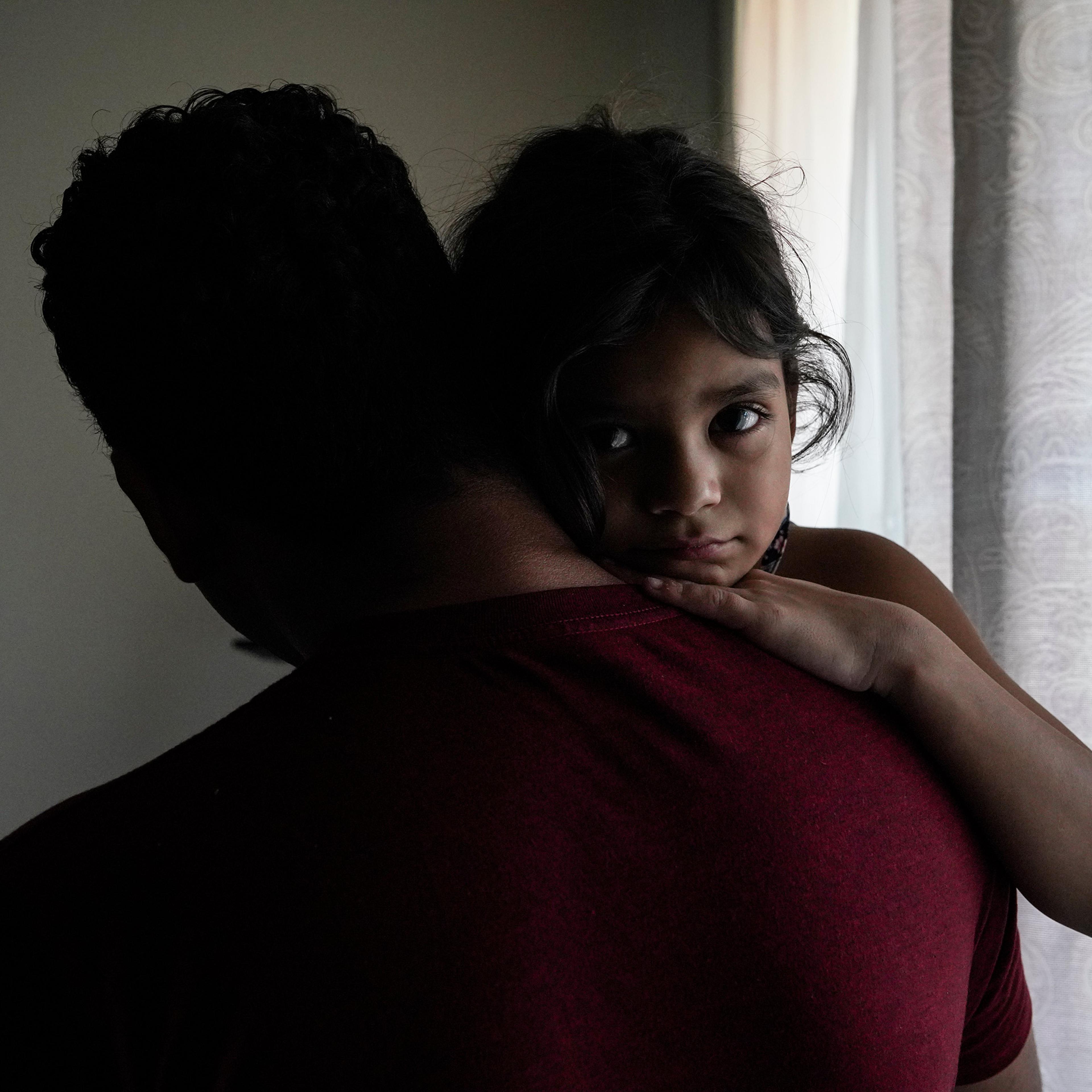 Heyli, 7, holds her dad Carlos at home in Los Angeles, California. They were separated for nearly two months last year after they sought asylum at the Texas border.