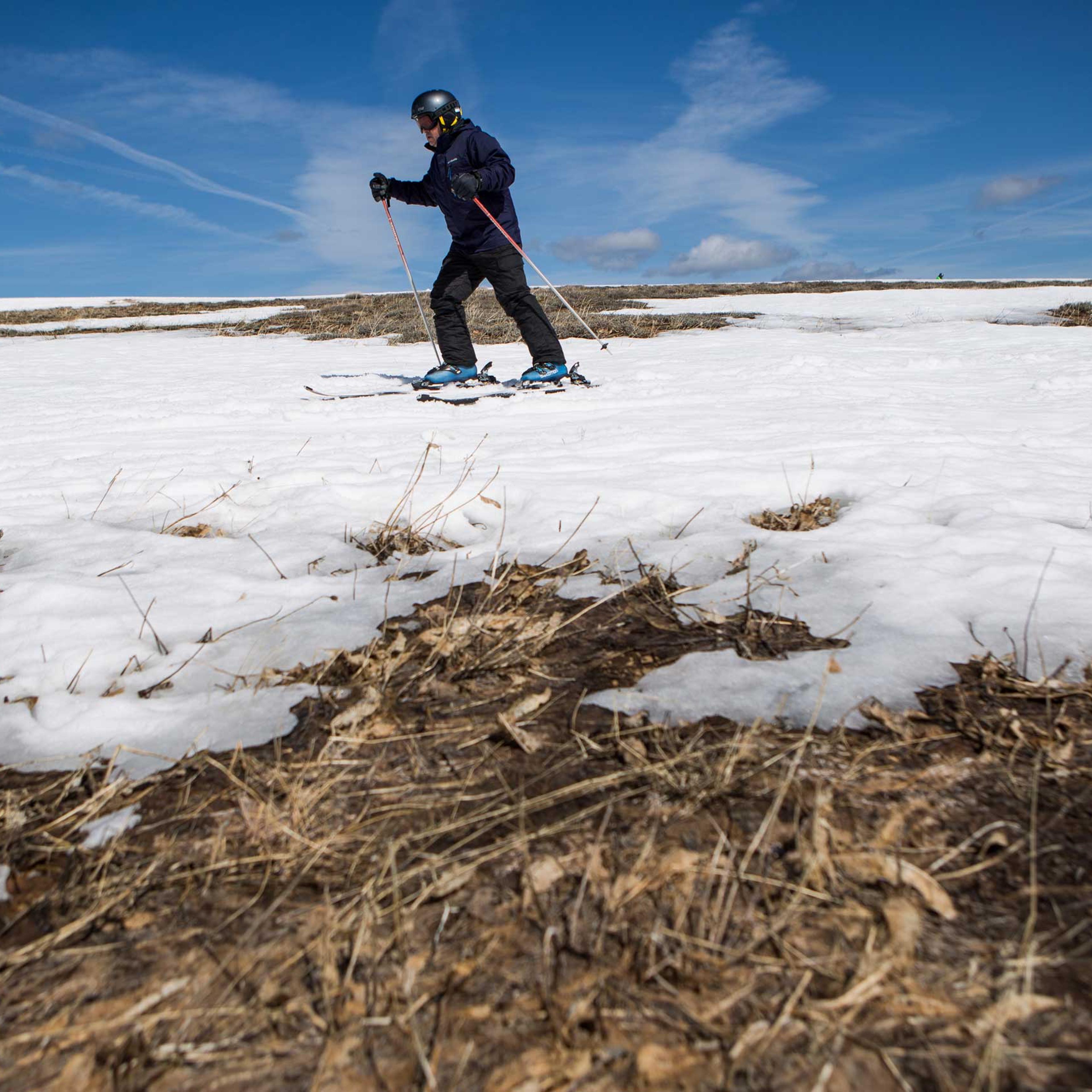 A skier threads his way through patches of dry ground at Squaw Valley Ski Resort in Olympic Valley, Calif., on March 21, 2015.