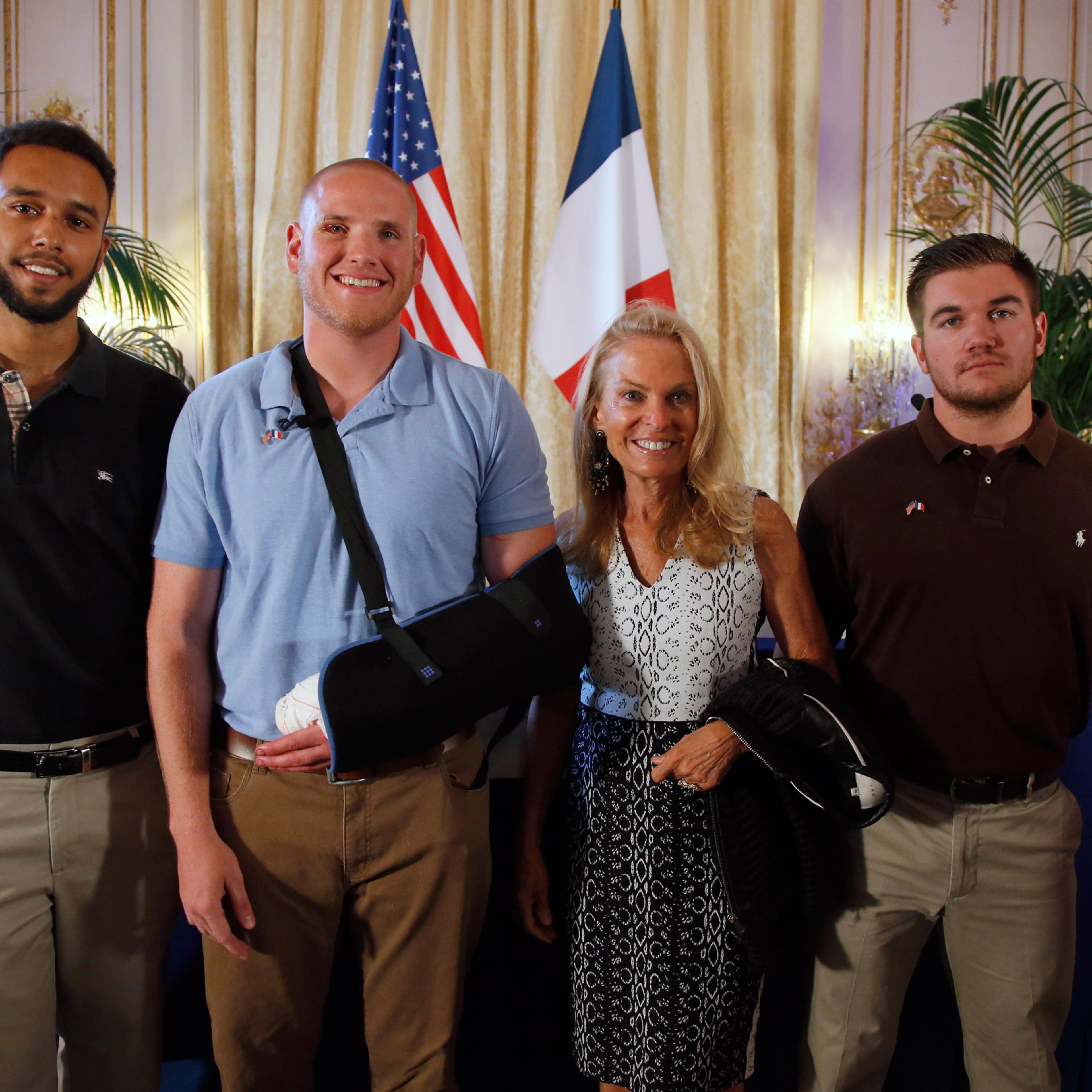 Anthony Sadler, a senior at Sacramento University in California, left, U.S. National Guardsman from Roseburg, Oregon, Alek Skarlatos, right, and U.S. Airman Spencer Stone, second from left, pose for photographers with Jane D. Hartley, U.S. Ambassador to