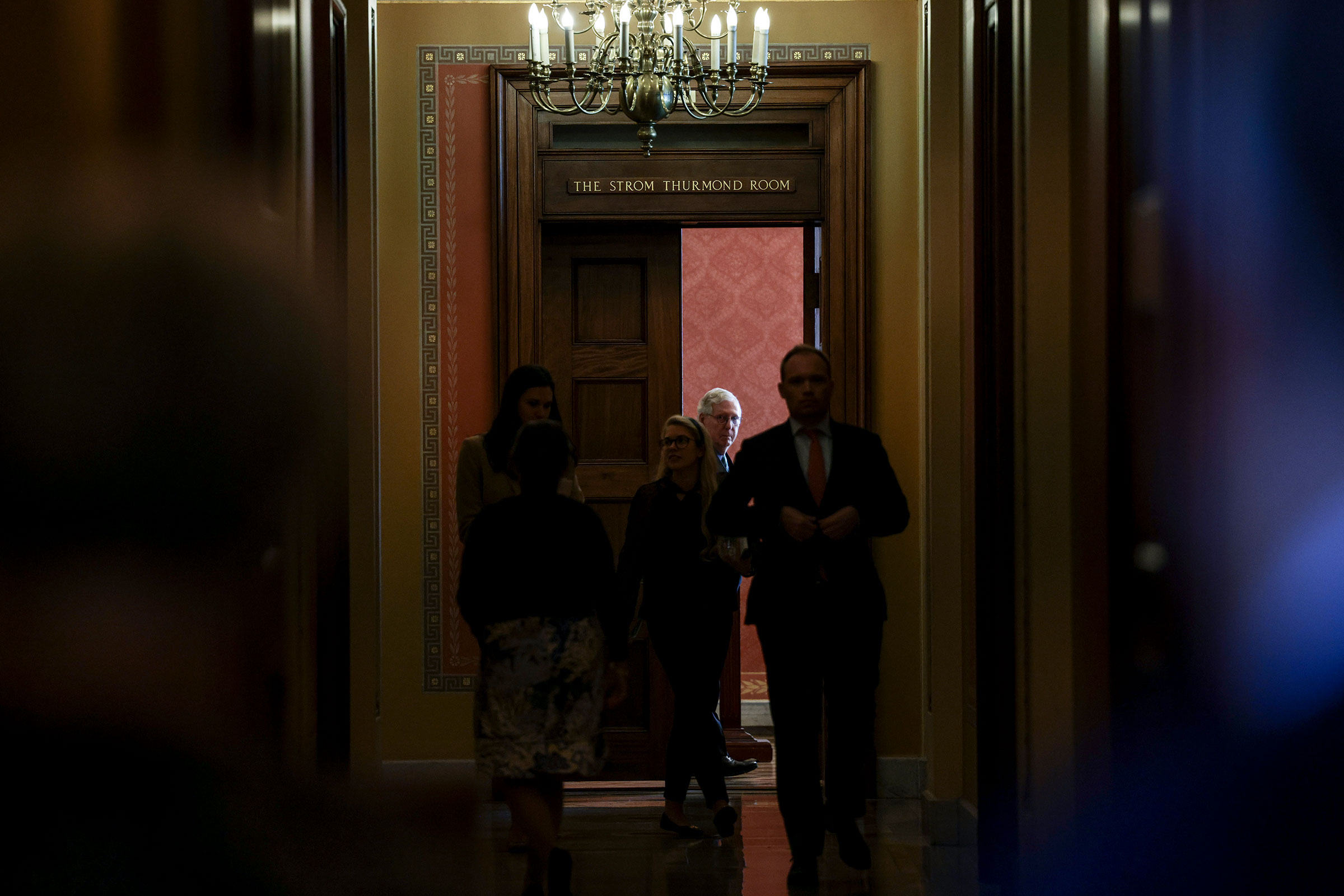 Senate Minority Leader Mitch McConnell watches Senators arrive to a meeting with Republican Senators on their party's plan for the vote on the debt limit at the Capitol on Oct. 7, 2021.