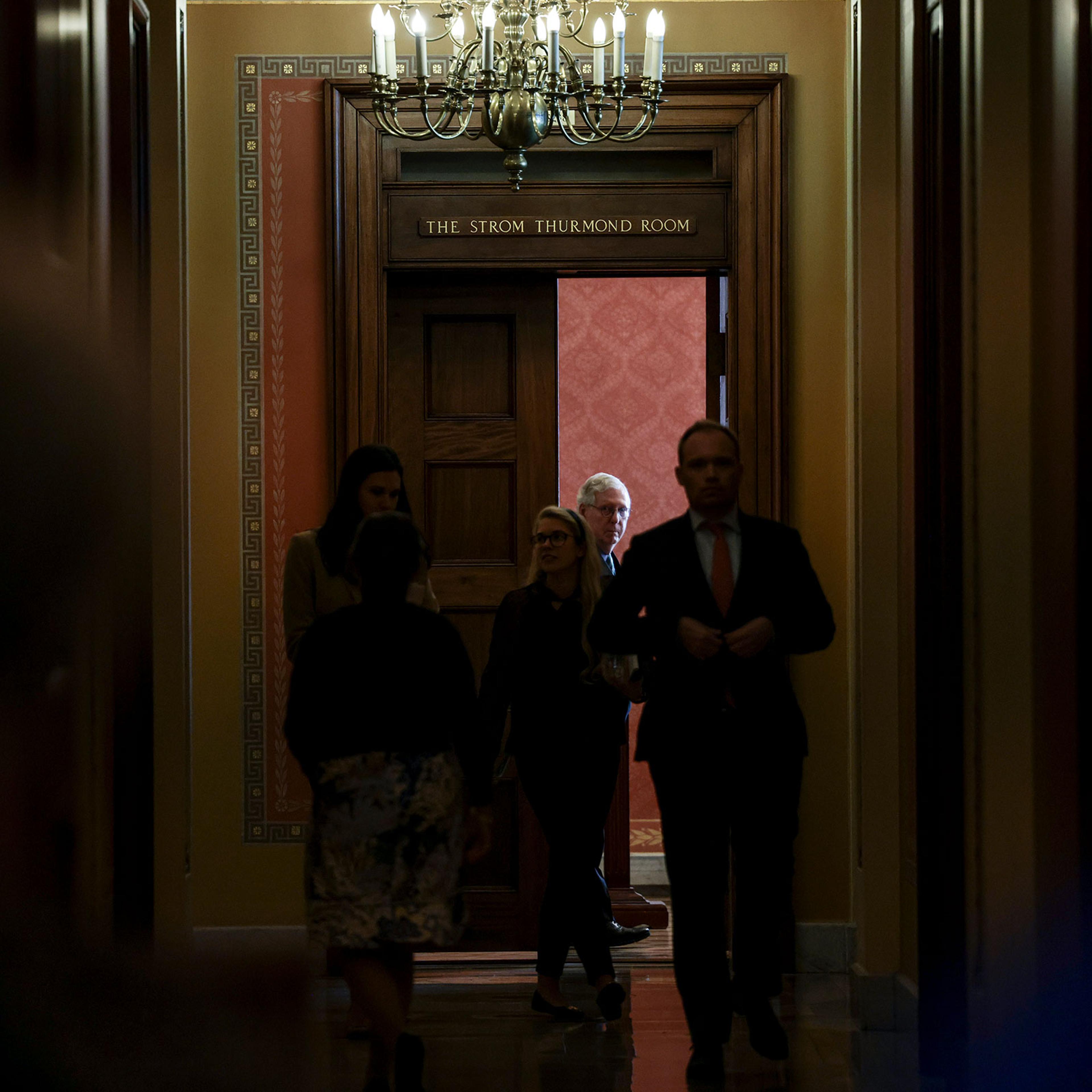 Senate Minority Leader Mitch McConnell watches Senators arrive to a meeting with Republican Senators on their party's plan for the vote on the debt limit at the Capitol on Oct. 7, 2021.