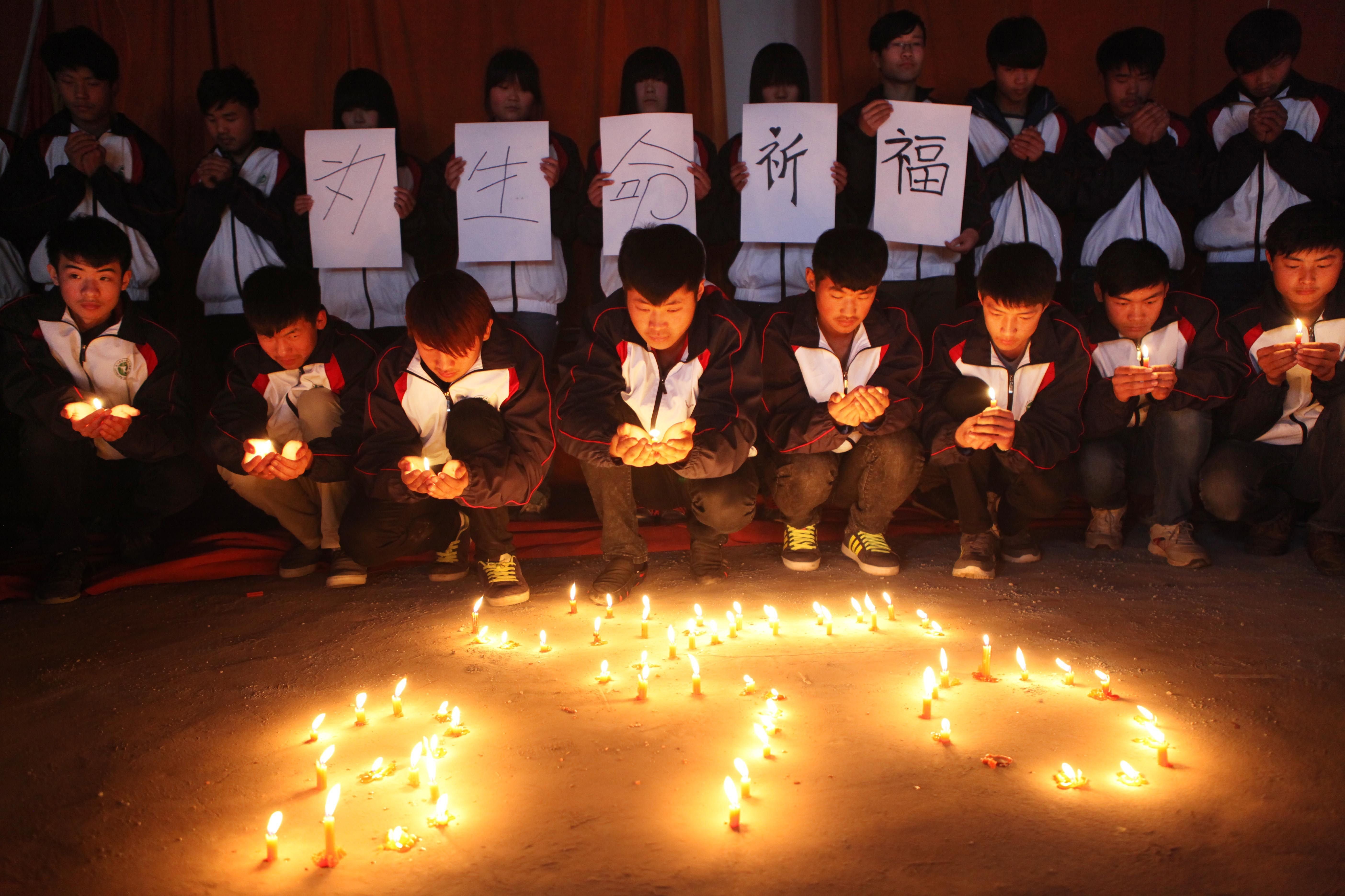 High school students in Lianyungang in Chinas eastern Jiangsu province hold a vigil for the passengers and crew of Flight MH 370