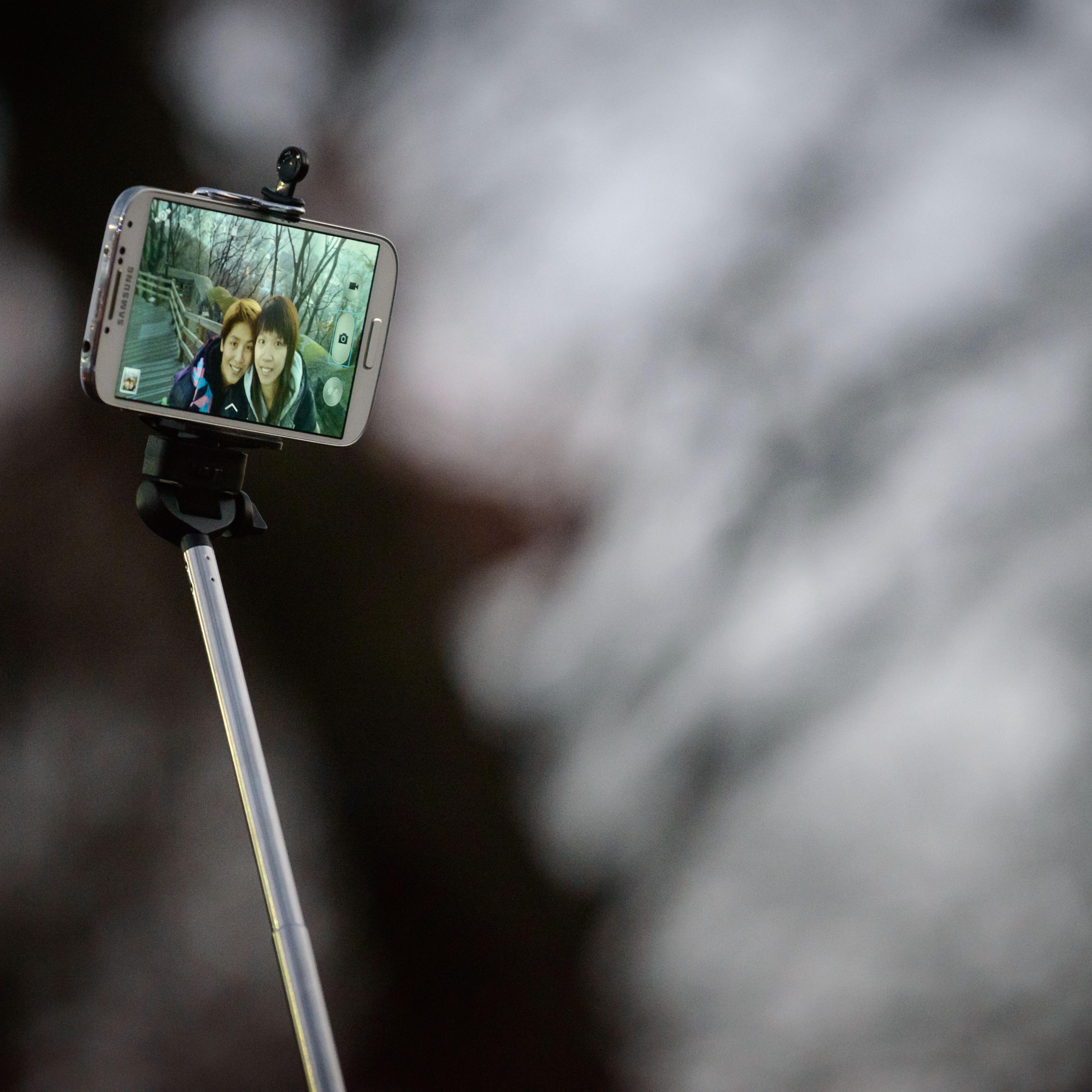 A couple use a 'selfie stick' to take a photo at a popular tourist spot in Seoul on Nov. 26, 2014.