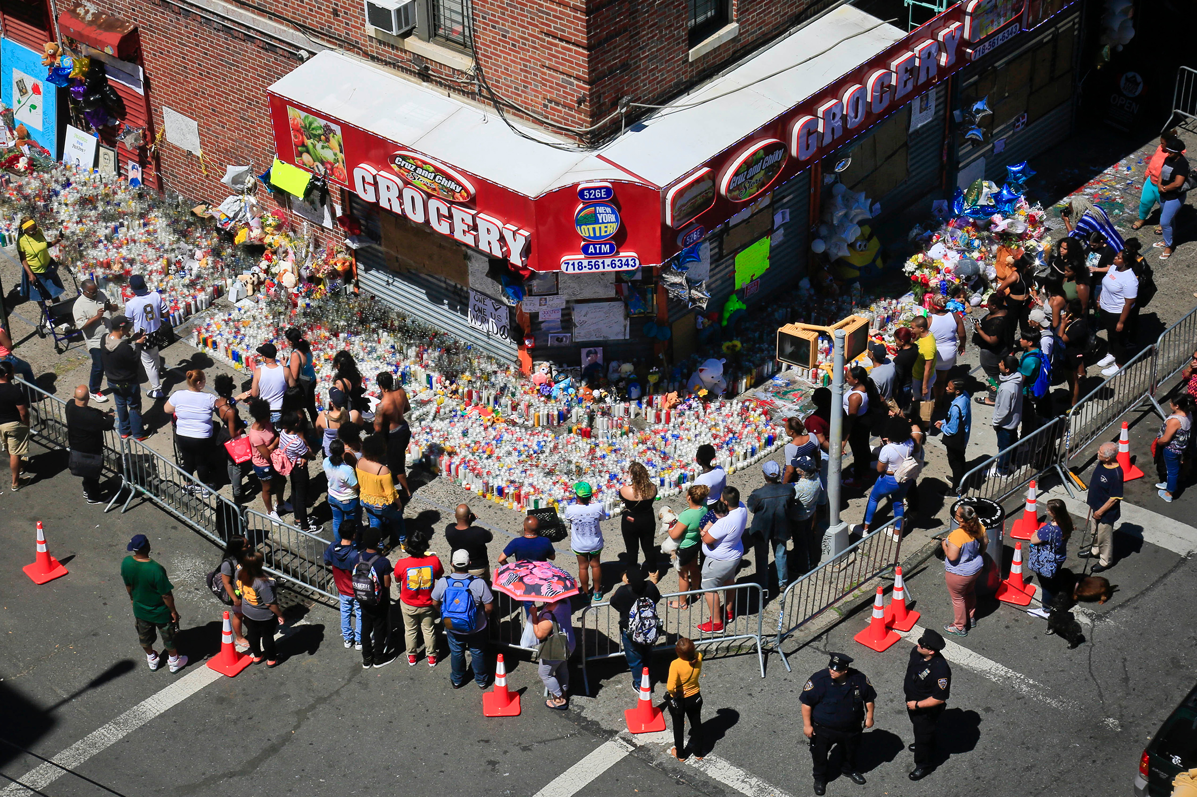 Mouners gather at a community memorial outside a bodega in New York, where 15-year-old Lesandro Guzman-Feliz was killed in a machete attack on Wednesday, on June 26, 2018.