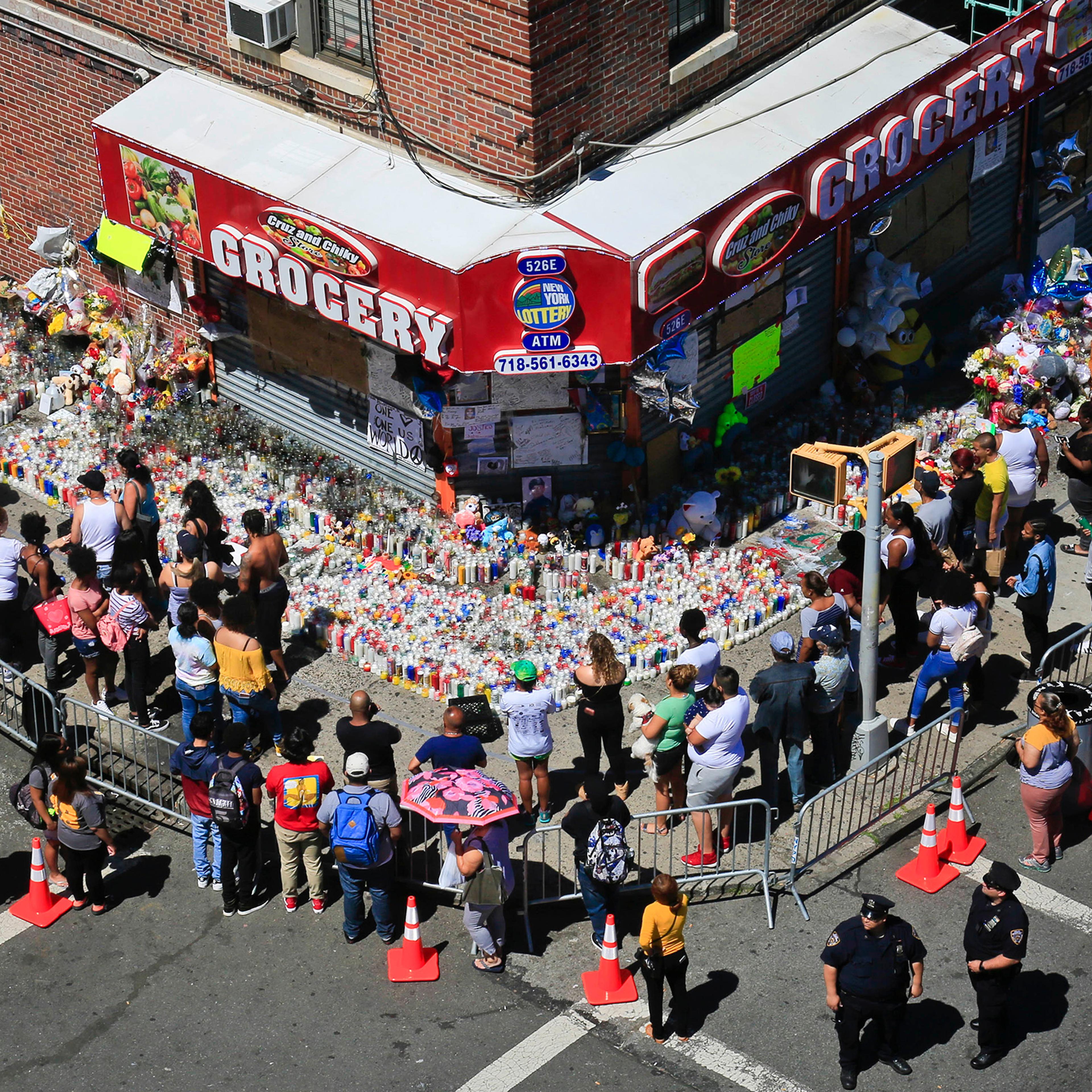 Mouners gather at a community memorial outside a bodega in New York, where 15-year-old Lesandro Guzman-Feliz was killed in a machete attack on Wednesday, on June 26, 2018.