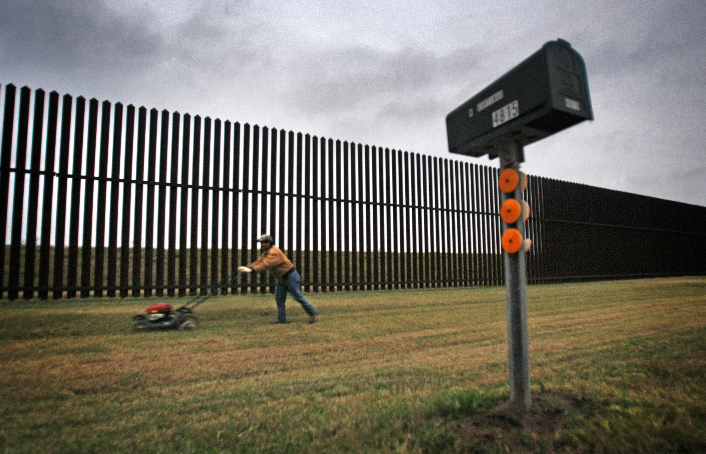 JANUARY 20, 2011. BROWNSVILLE, TEXAS. A resident on Oklahoma Avenue outside Brownsville, Texas mows