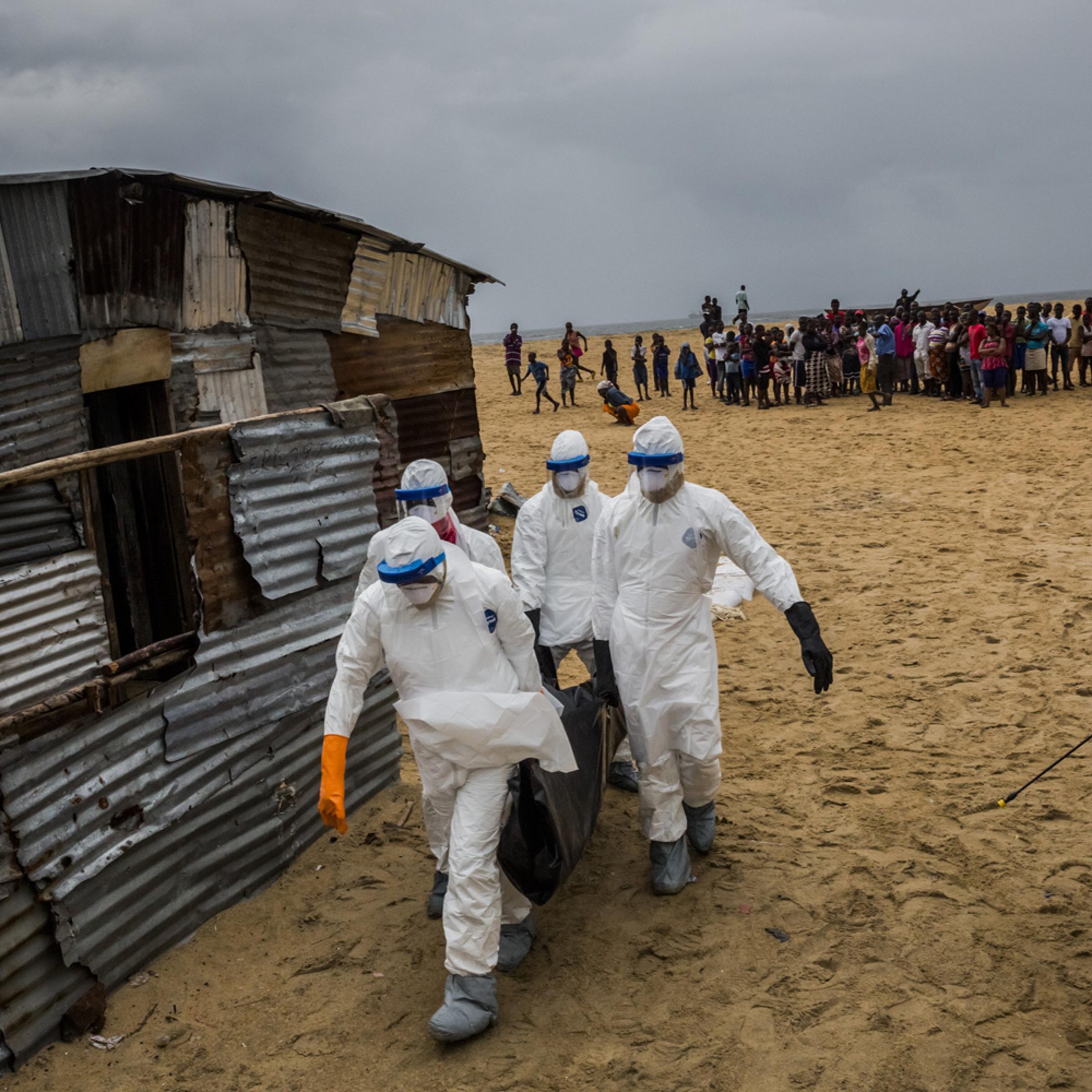 Liberian Red Cross burial team carry a body of a suspected Ebola victim from the West Point neighborhood in Monrovia, Liberia, Sept. 17, 2014.