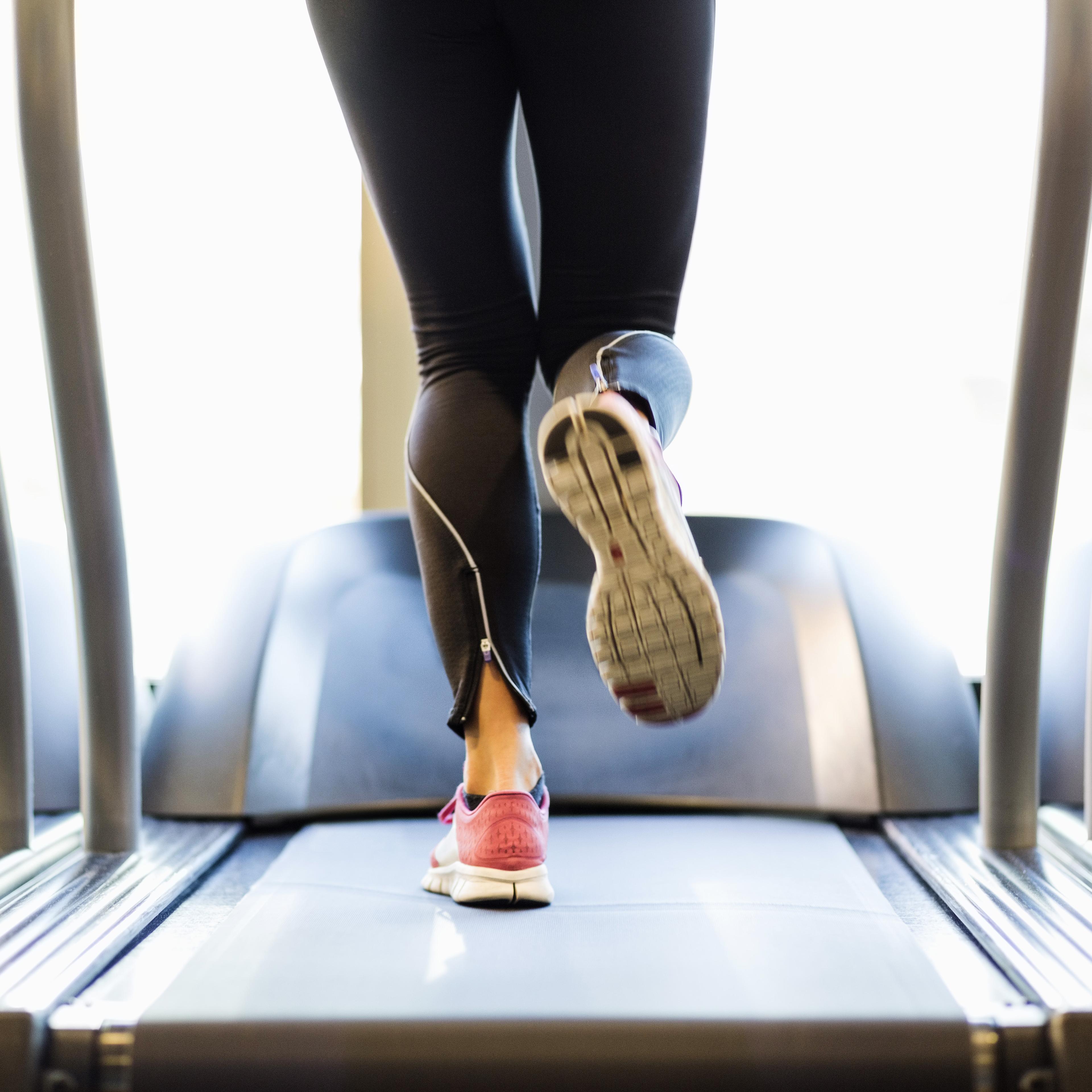 Low section of woman exercising on treadmill