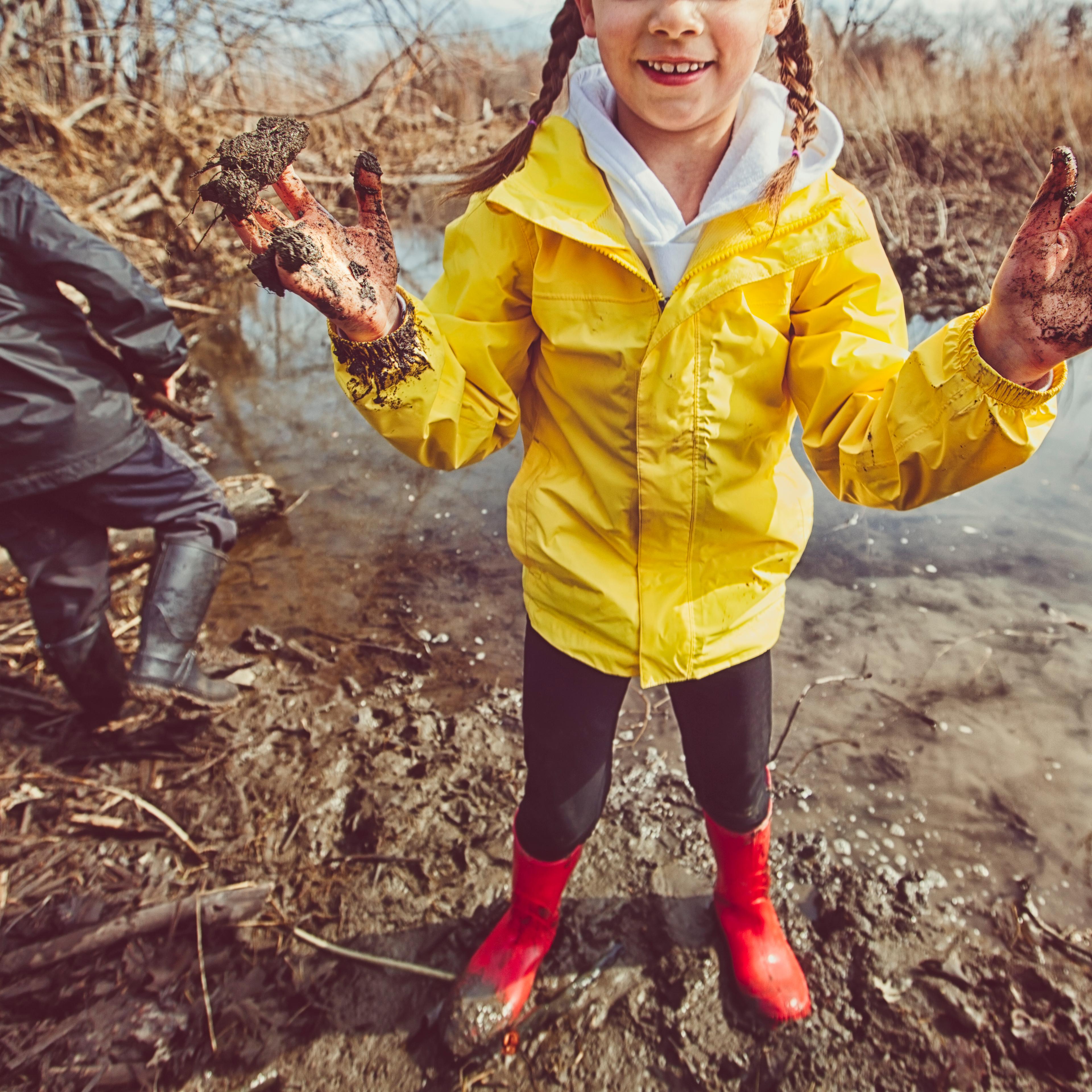 Girl and boy playing in mud