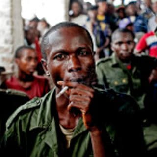February 21, 2011. Sido Bizinungu, a close associate of Lt. Col. Mutuare Daniel Kibibi, smokes a cigarette after being convicted of crimes against humanity in the town of Baraka, Congo. Nearly 50 women poured out their stories in a wave of anguish that ended with the conviction of an army colonel for crimes against humanity—a landmark verdict in this Central African country where thousands are believed to be raped each year by soldiers and militia groups who often go unpunished.