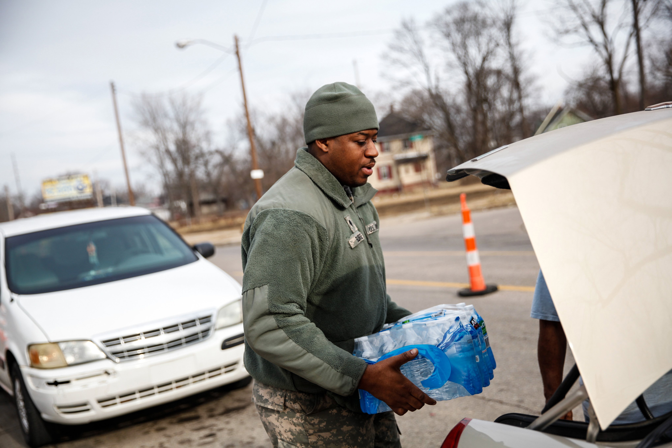 FLINT, MI - FEBRUARY 7: Army National Guard Spc. Terence Burse carries bottled water out to the car for a resident on February 7, 2016 in Flint, Michigan. Months ago the city told citizens they could use tap water if they boiled it first, but now say it 