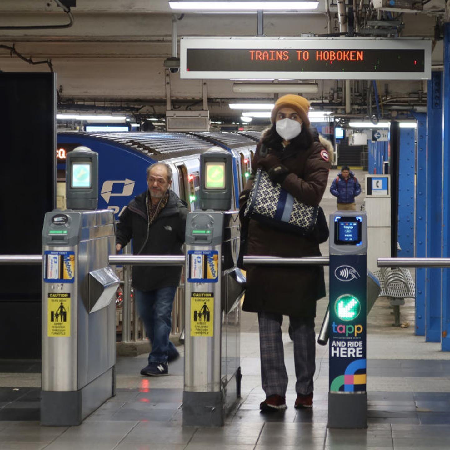 A woman wears a mask in a subway station.