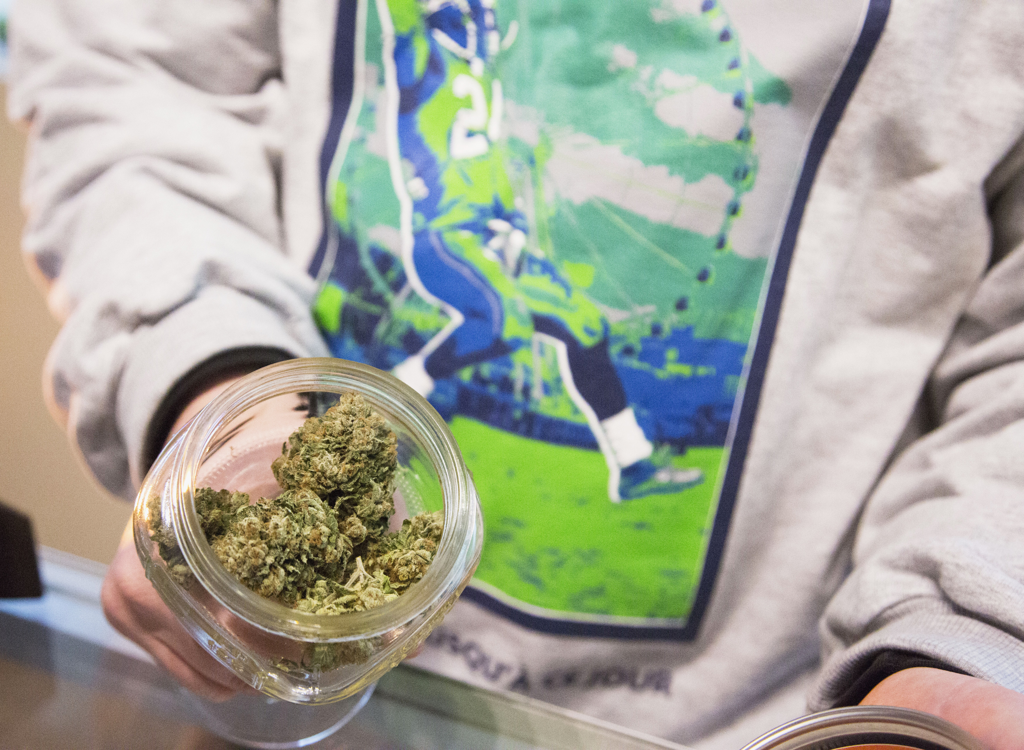 Johnson, managing owner of Queen Anne Cannabis Club, shows off marijuana strain "Beast Mode OG", in Seattle